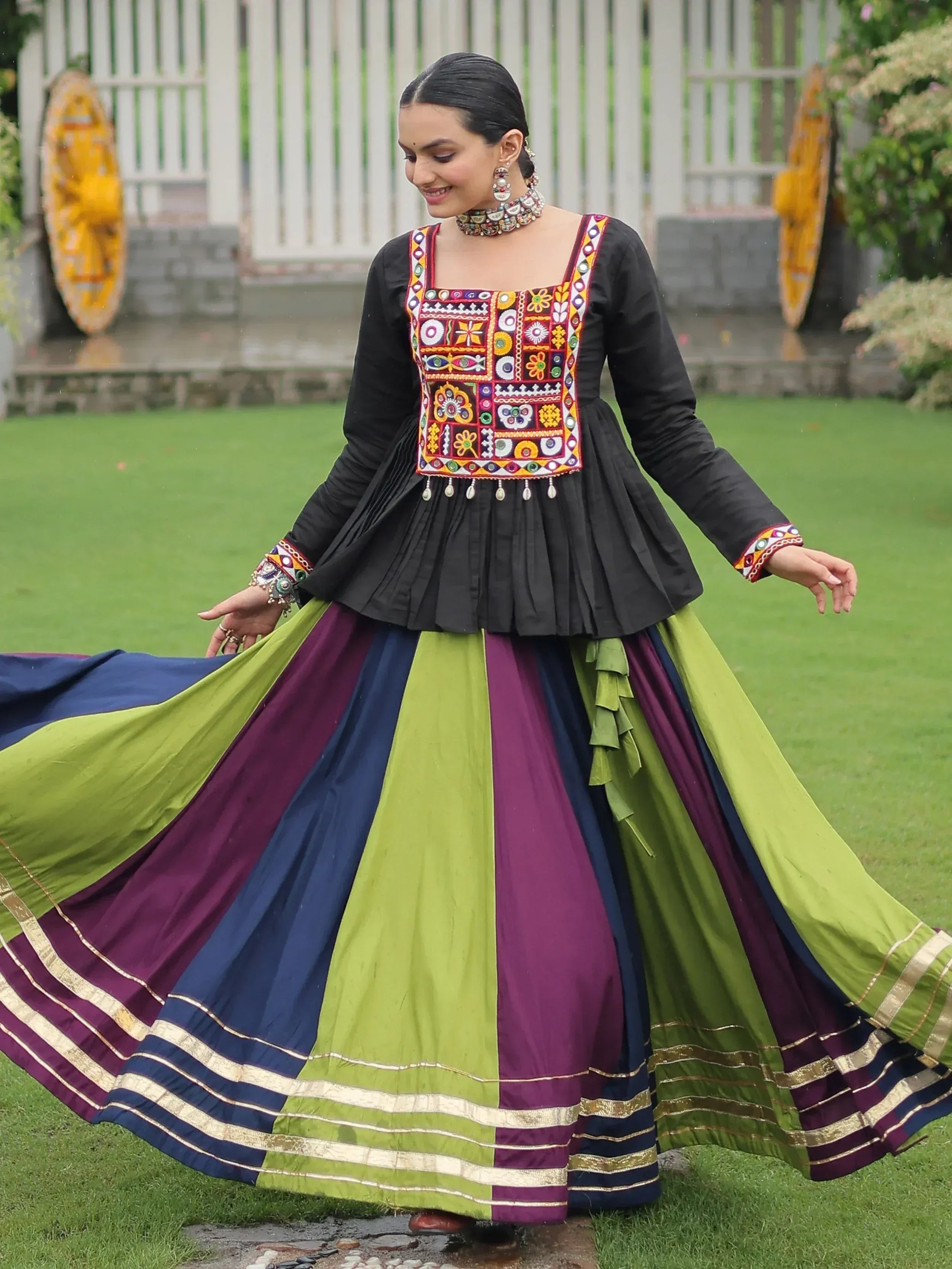 Colorful ethnic gown with embroidered top and pleated skirt, perfect for festive occasions