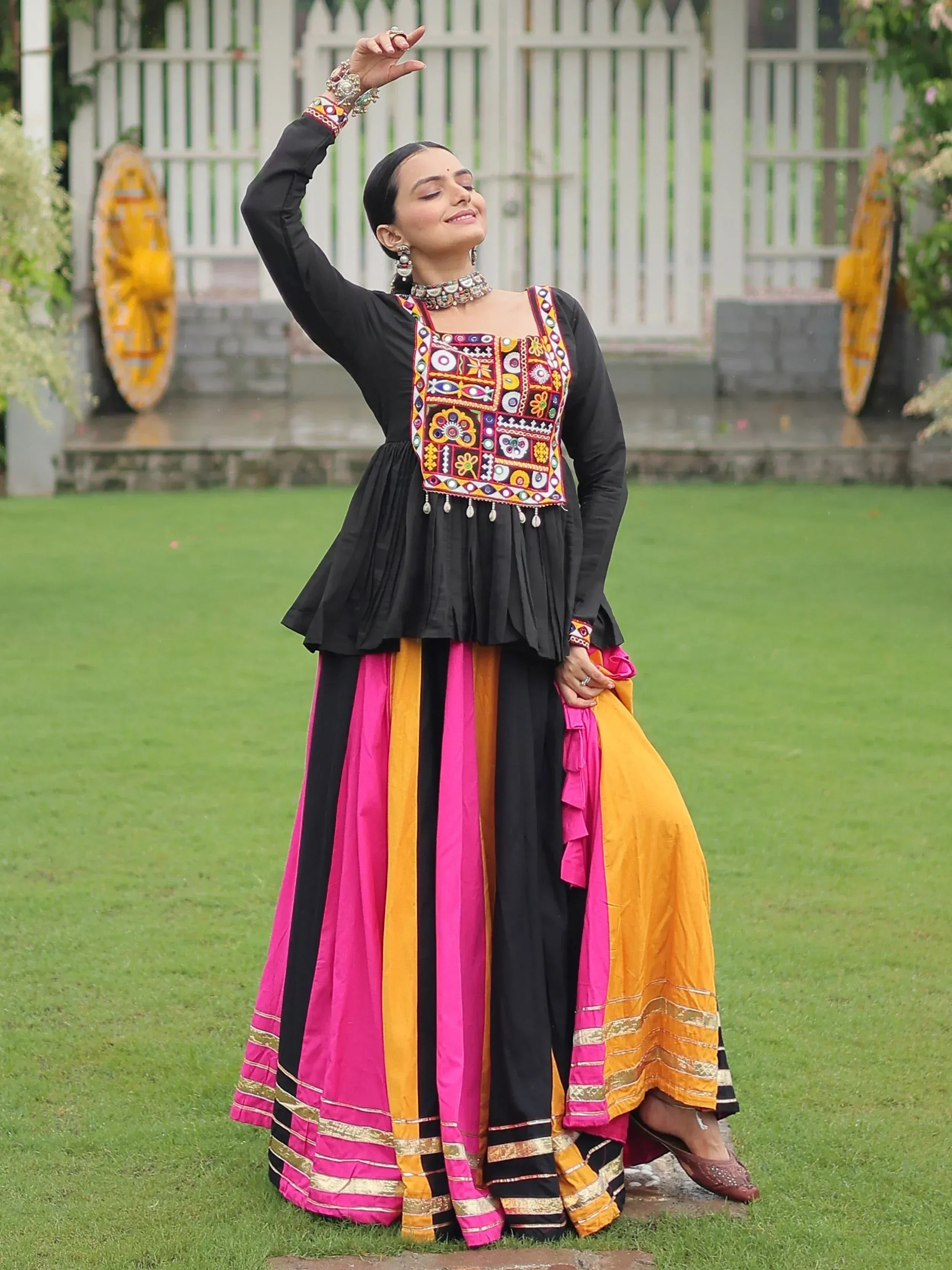 Woman in black embroidered top with colorful striped skirt, traditional Indian ethnic wear