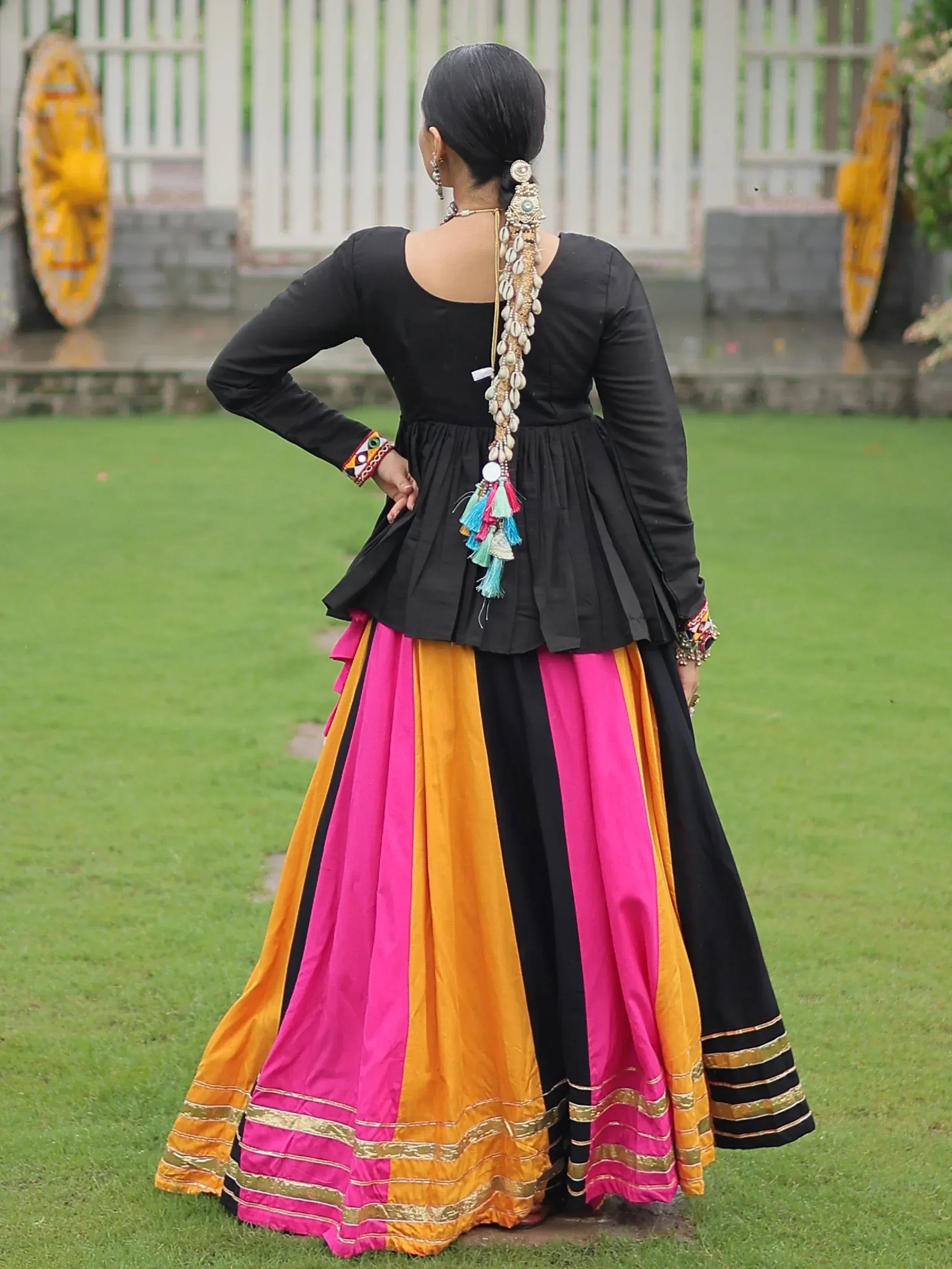 Black top with vibrant pink and orange striped skirt, traditional Indian ethnic wear