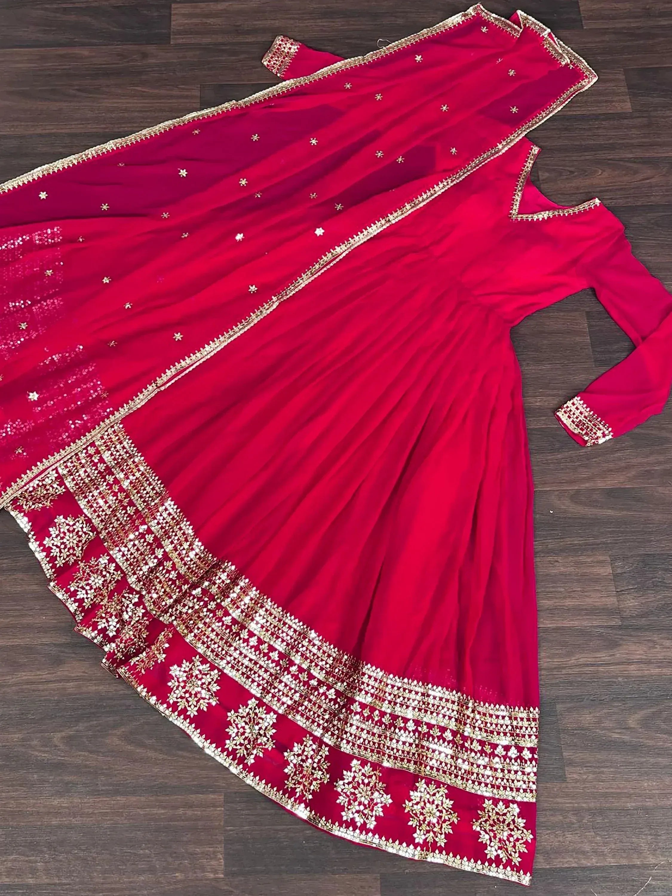 Pink embroidered Indian ethnic gown with matching dupatta on wooden floor