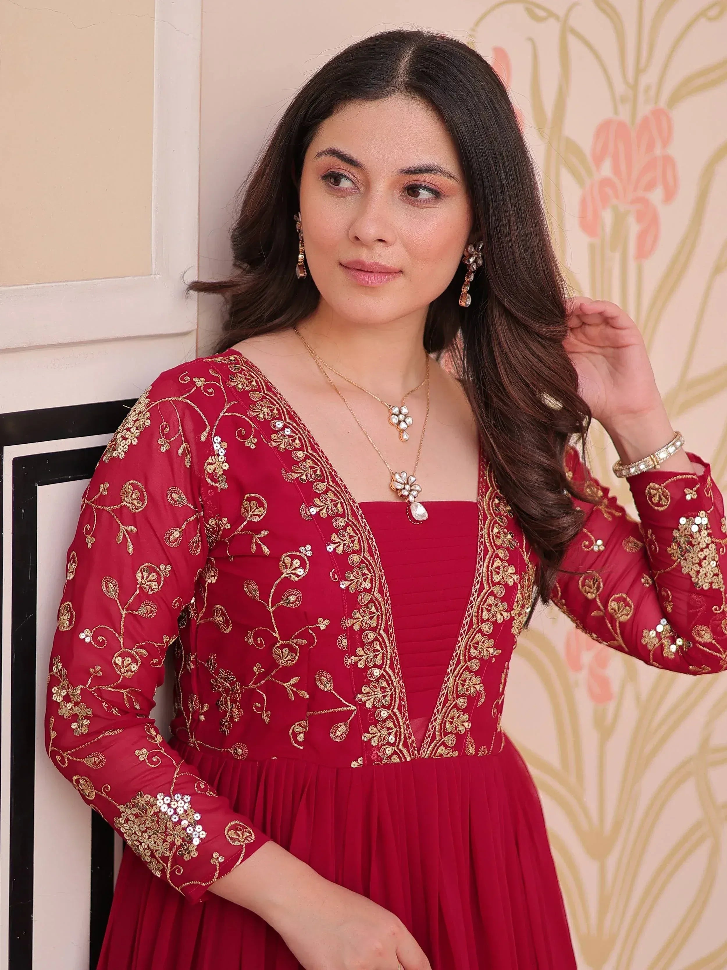 Red ethnic gown with gold embroidery and floral detailing, perfect for Indian celebrations.