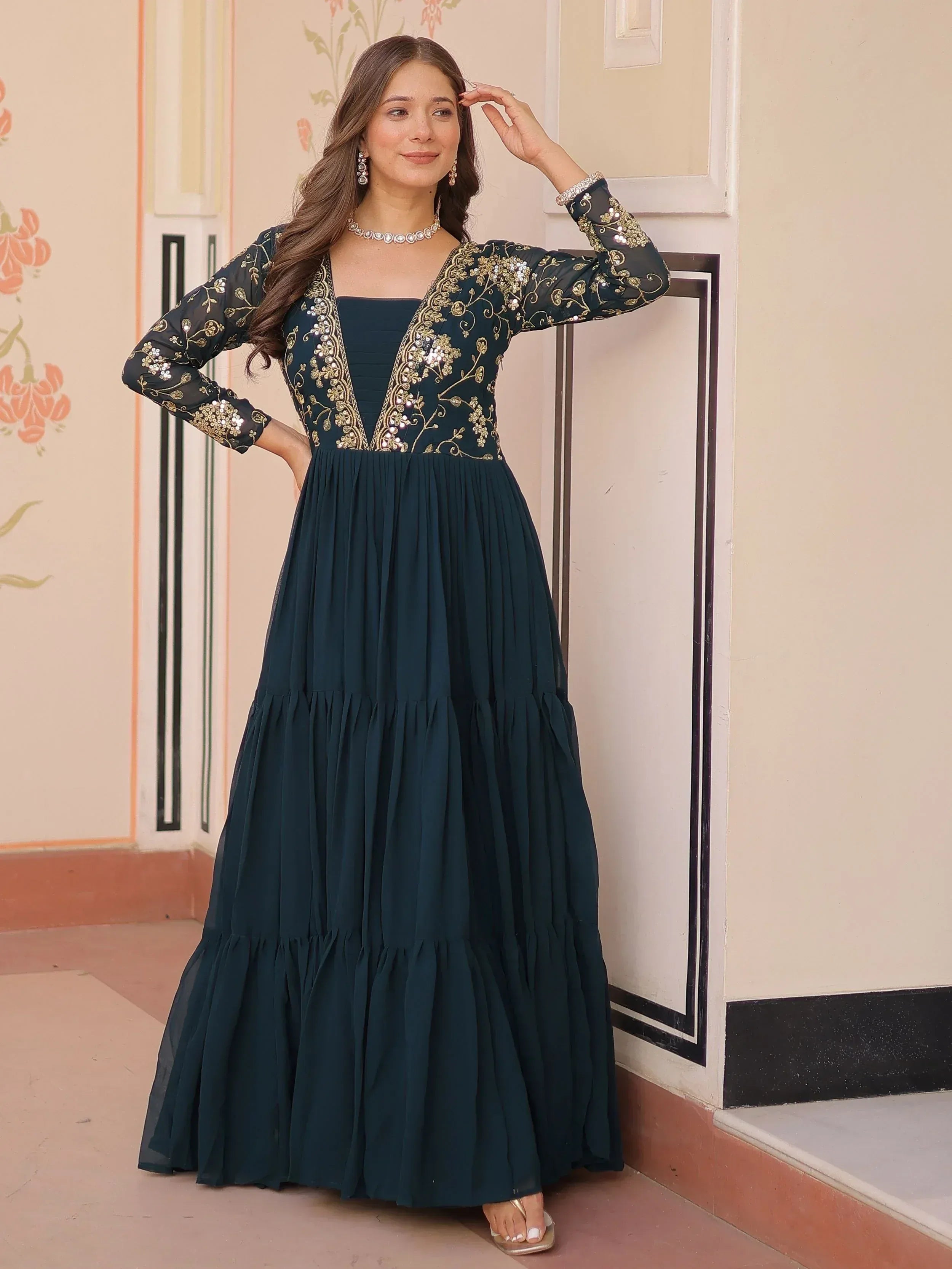Elegant dark green ethnic gown with gold embroidery and sheer sleeves, perfect for Indian occasions.