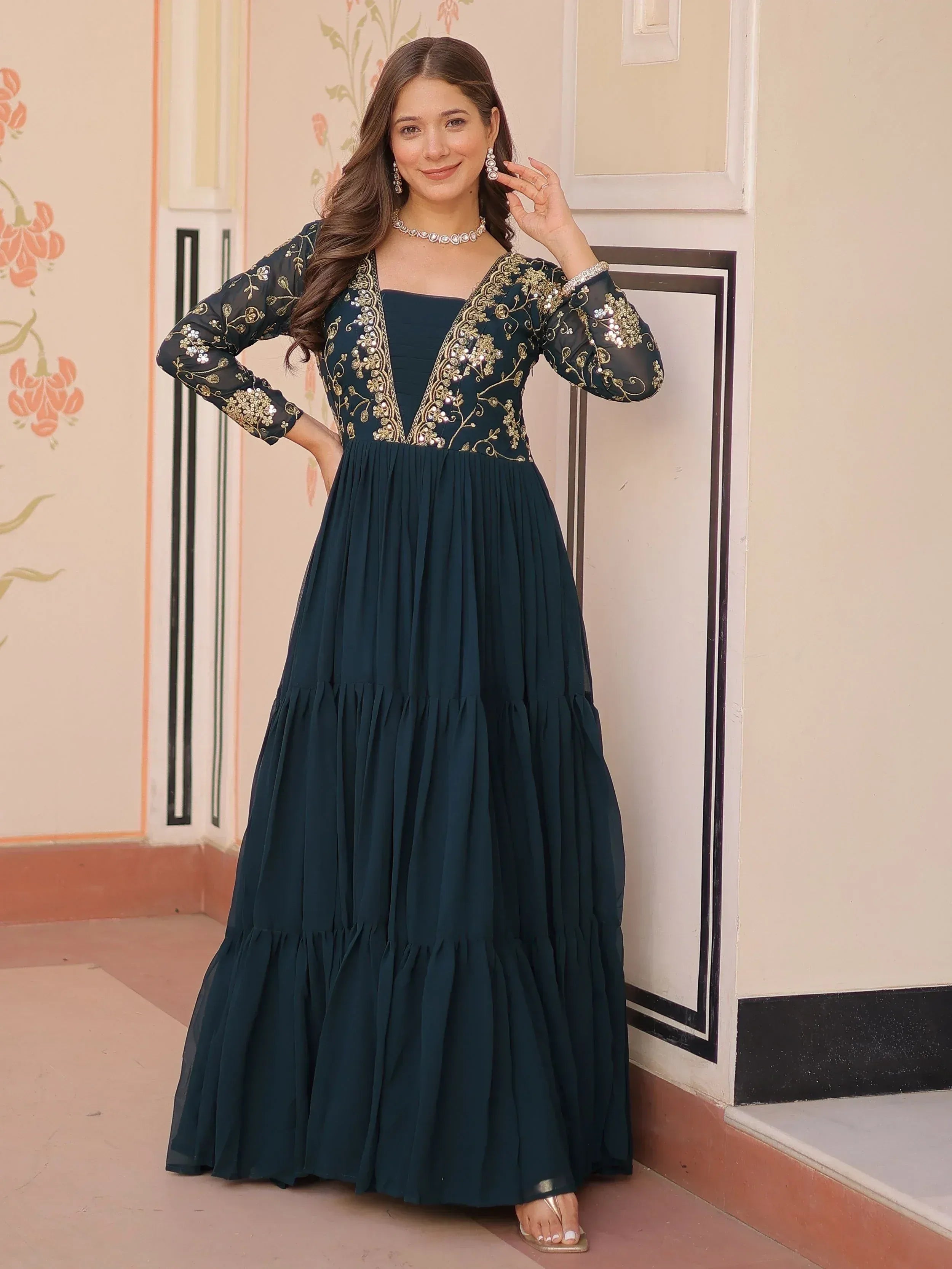 Elegant dark green ethnic gown with gold embroidery and sheer sleeves, perfect for Indian celebrations