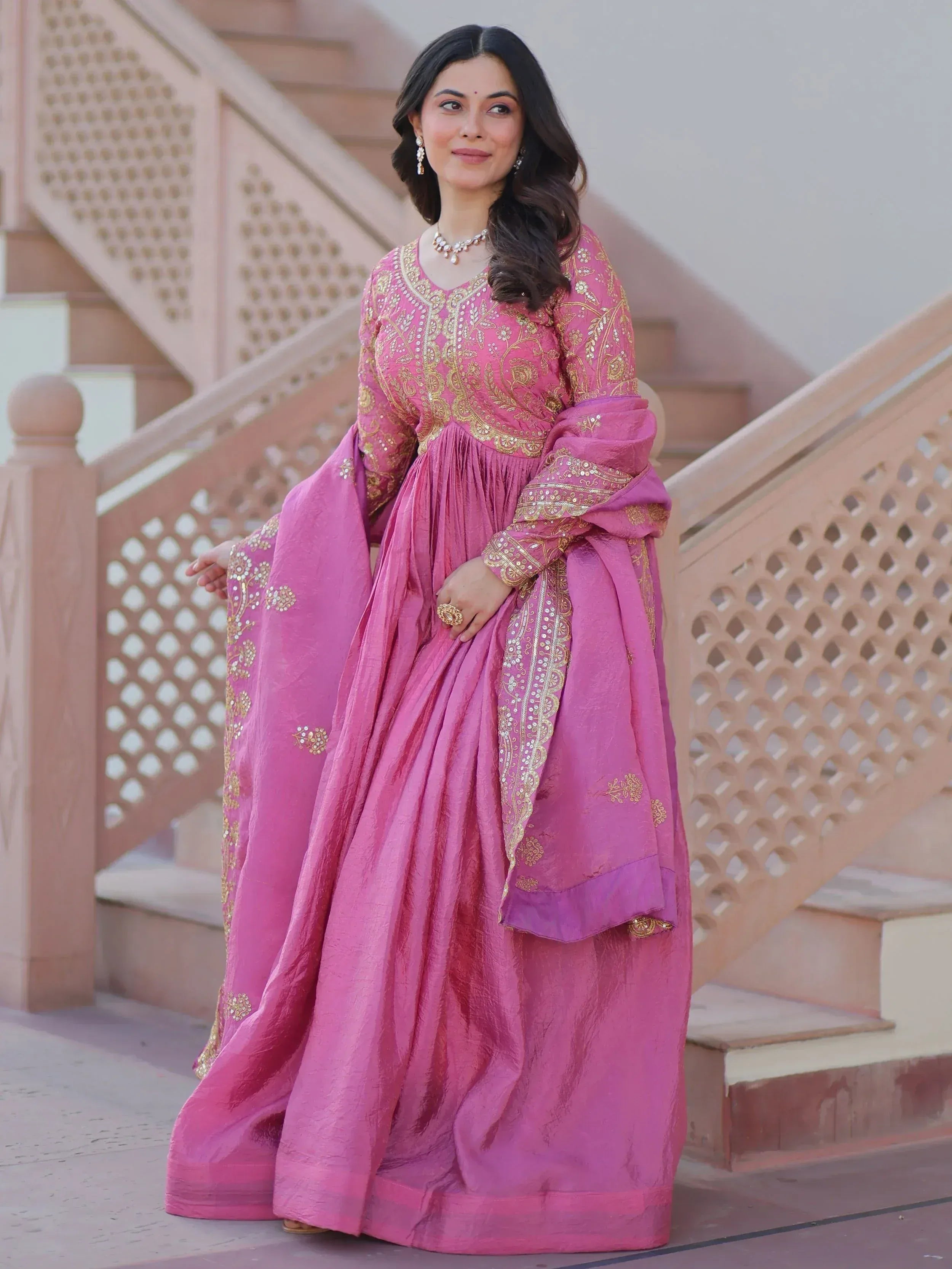 Pink ethnic gown with gold embroidery, perfect for Indian weddings and festive occasions.