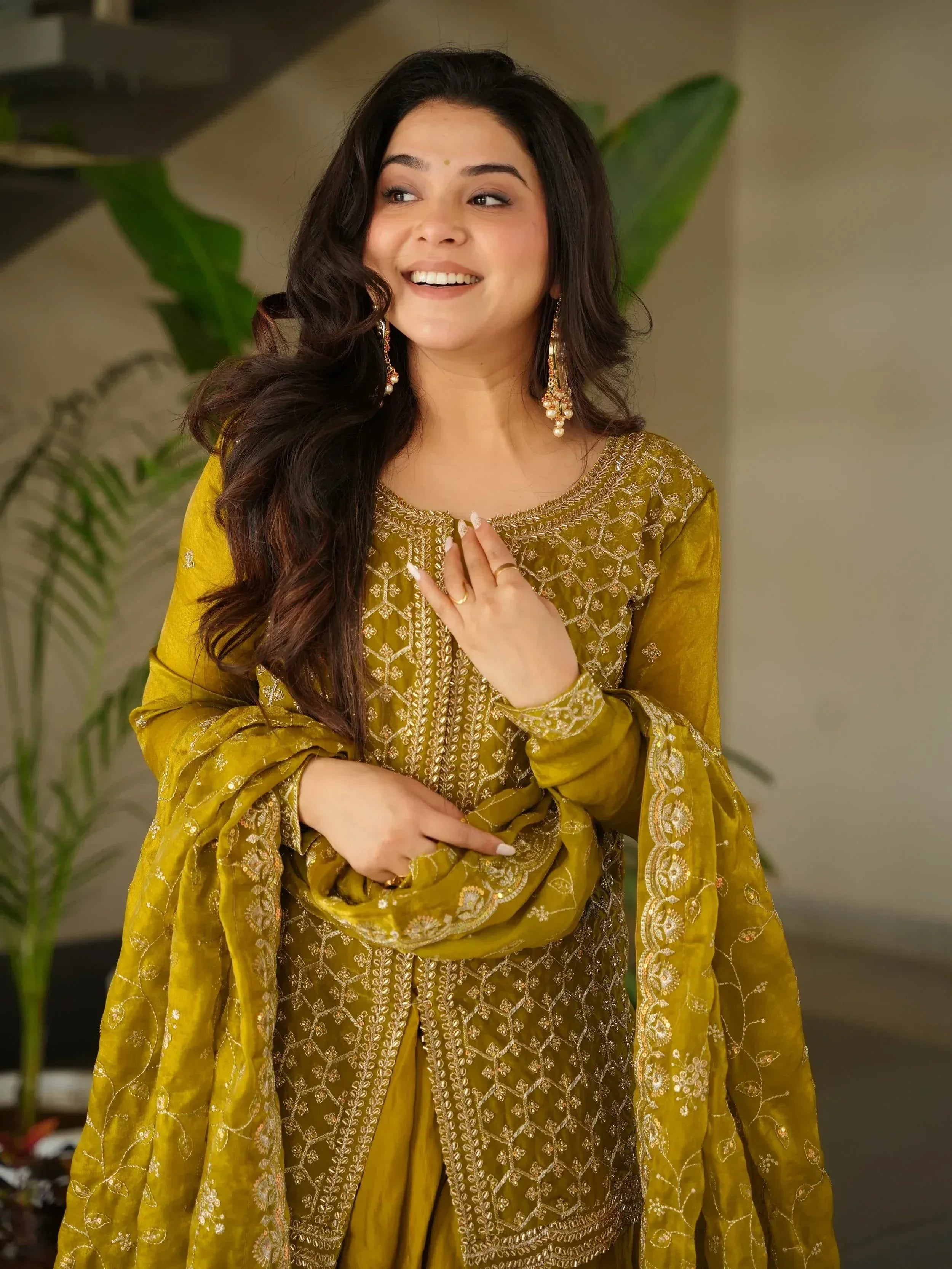 Woman in mustard yellow embroidered salwar kameez with gold detailing, perfect for Indian ethnic wear occasions.