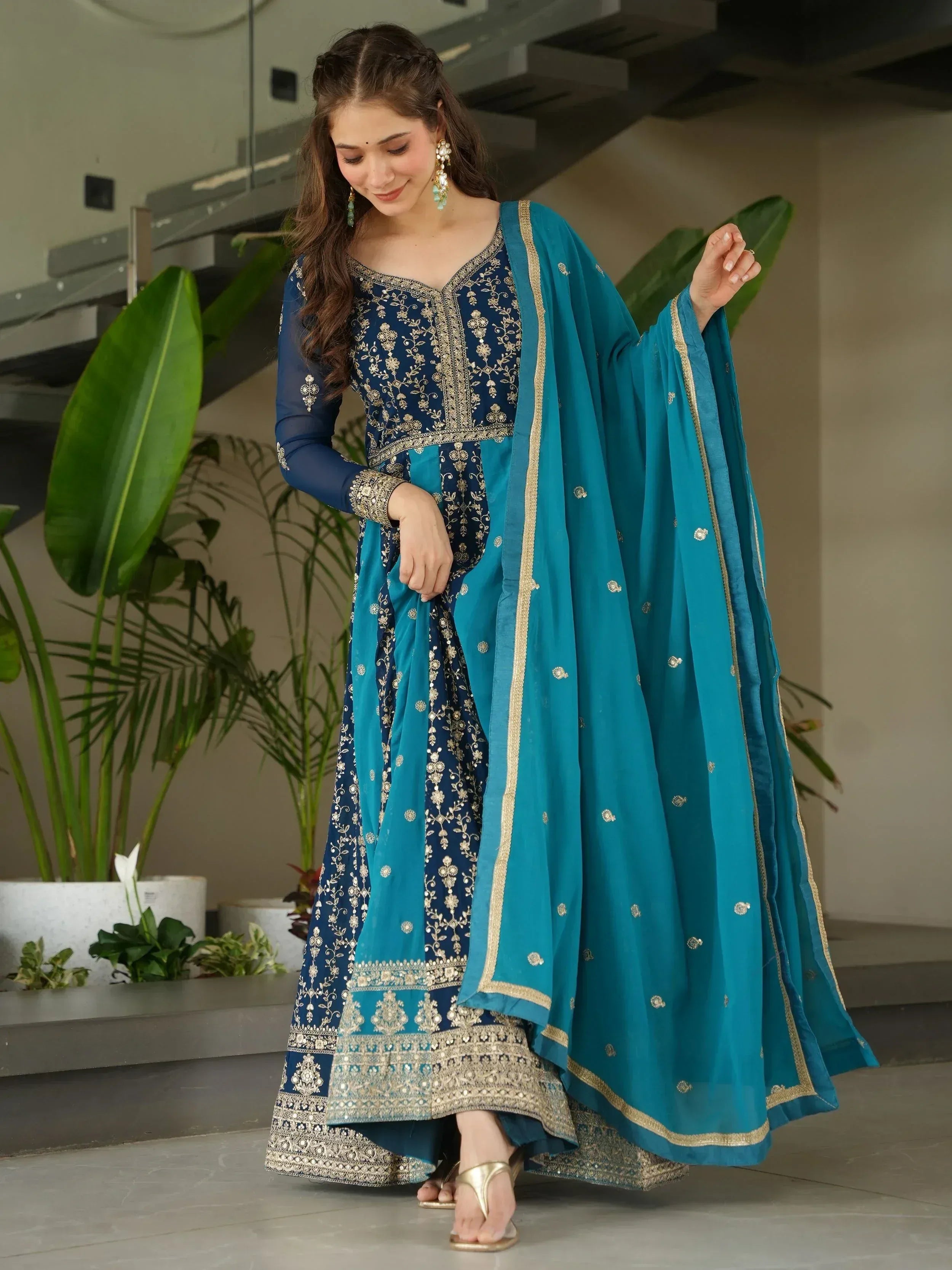 Blue embroidered ethnic anarkali suit with gold detailing and matching dupatta, perfect for Indian occasions.