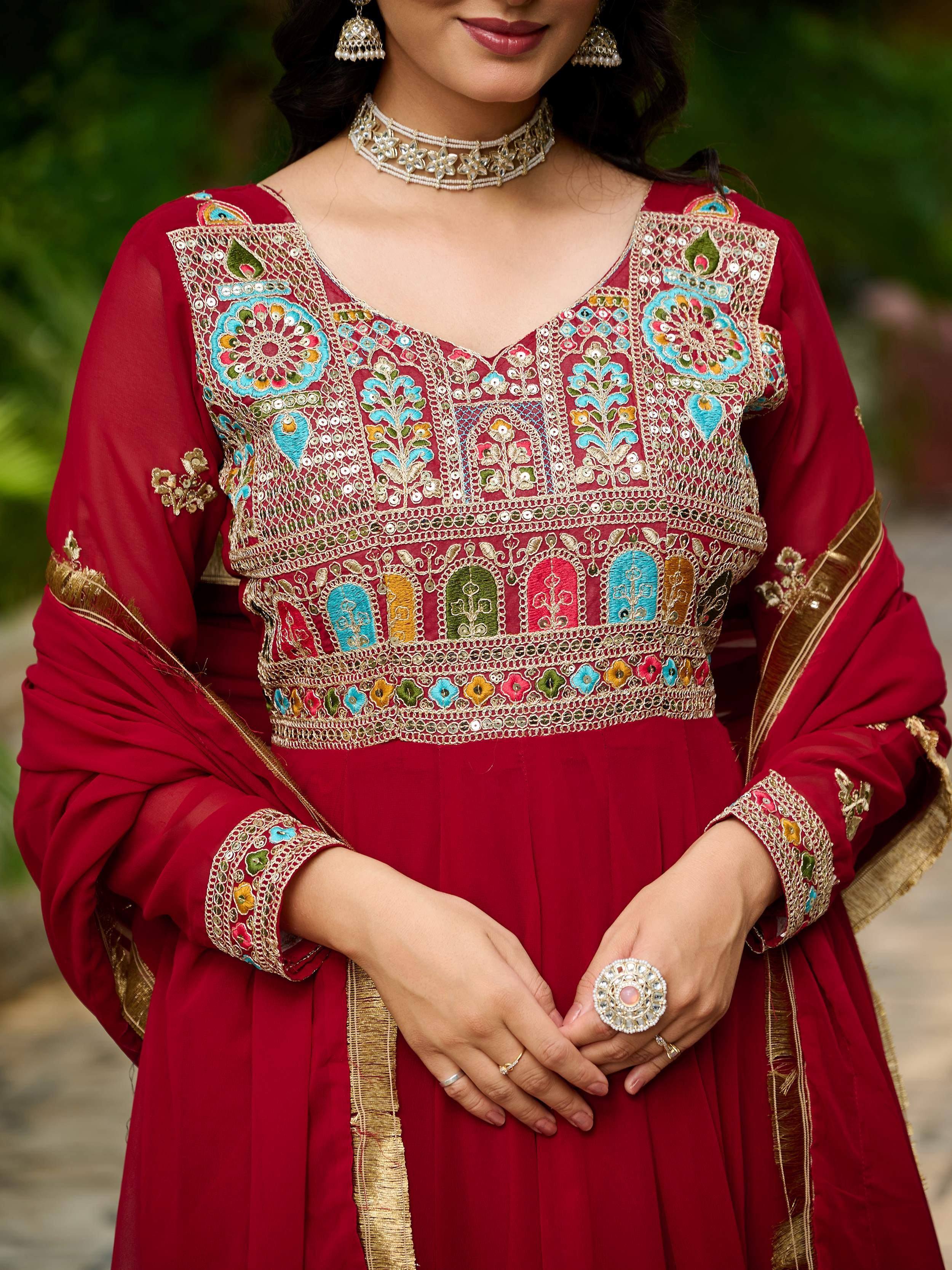 Red embroidered ethnic gown with colorful floral patterns and gold detailing