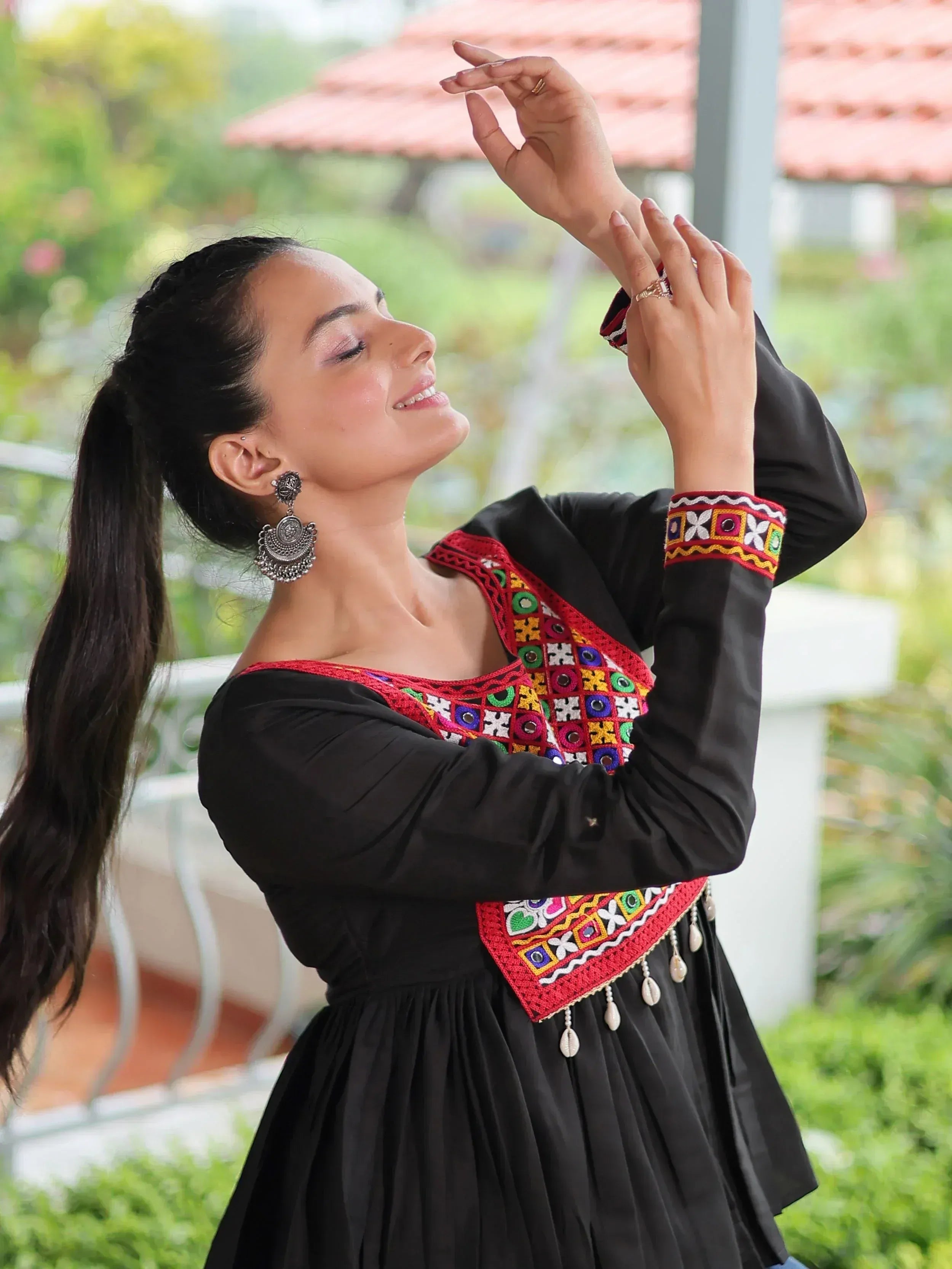 Woman in black ethnic gown with colorful mirror embroidery, perfect for Indian festive wear