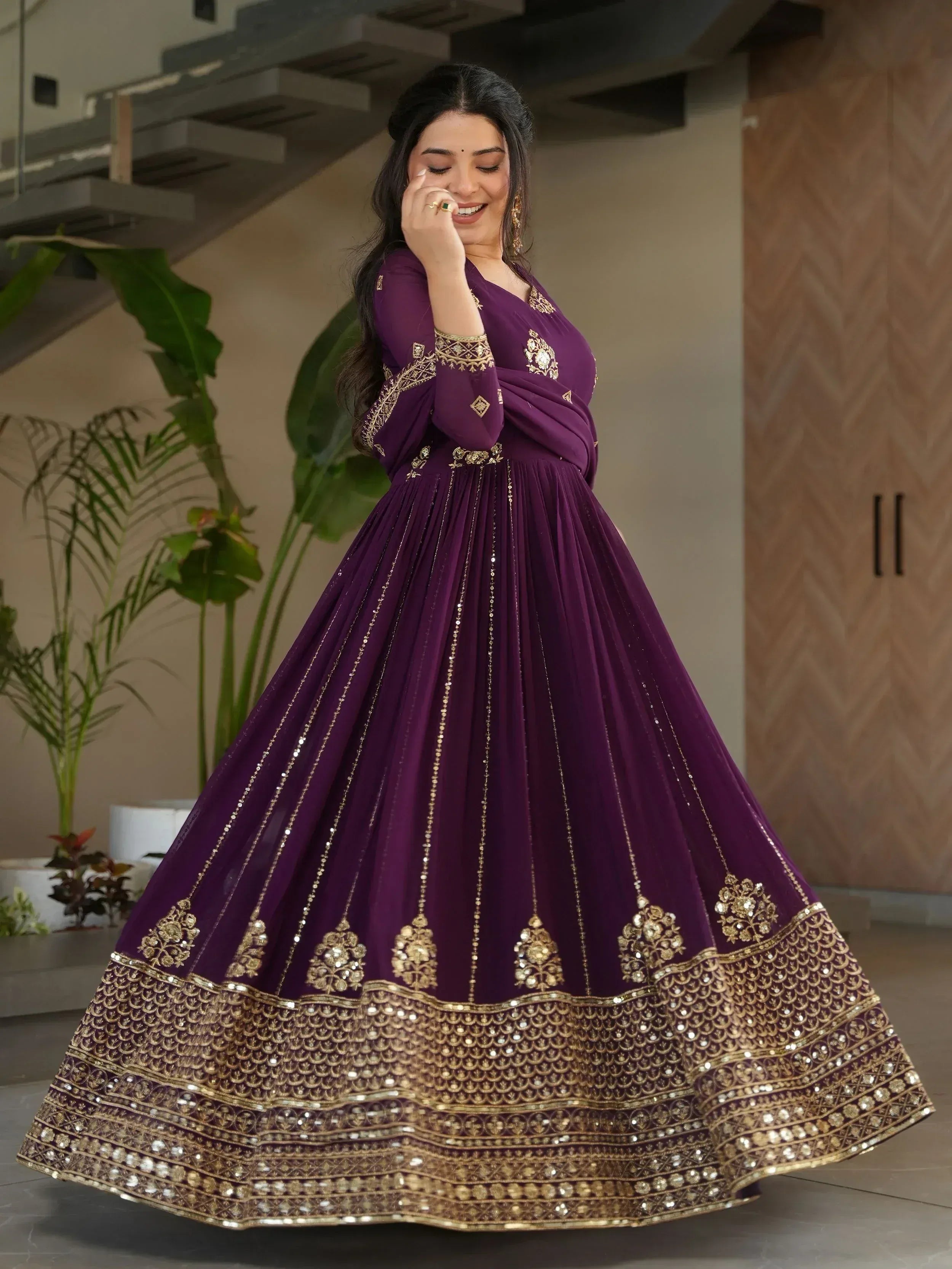 Elegant purple ethnic gown with gold embroidery and sequin detailing for festive occasions