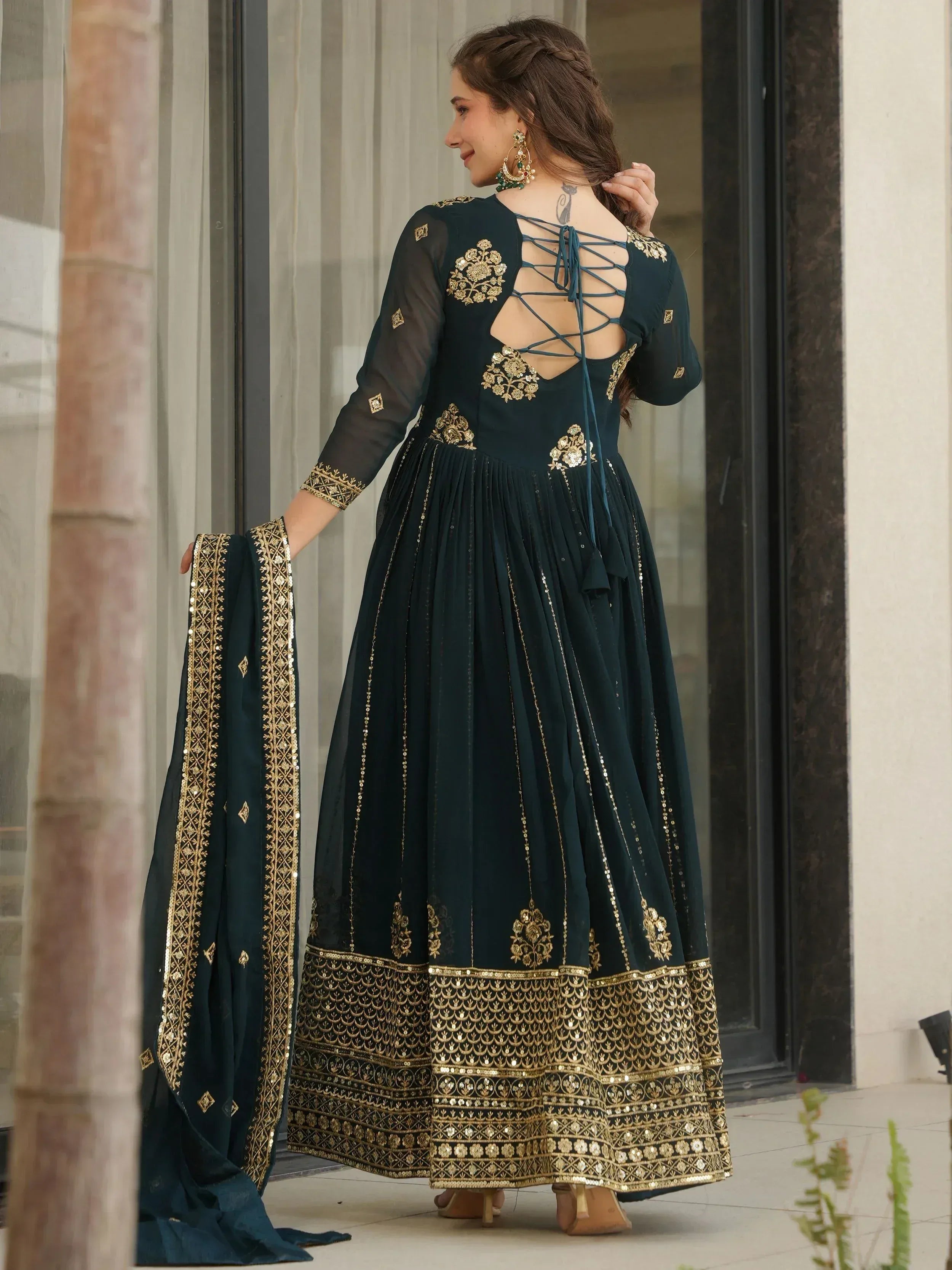 Elegant dark green ethnic gown with gold embroidery and lace-up back, perfect for festive occasions.