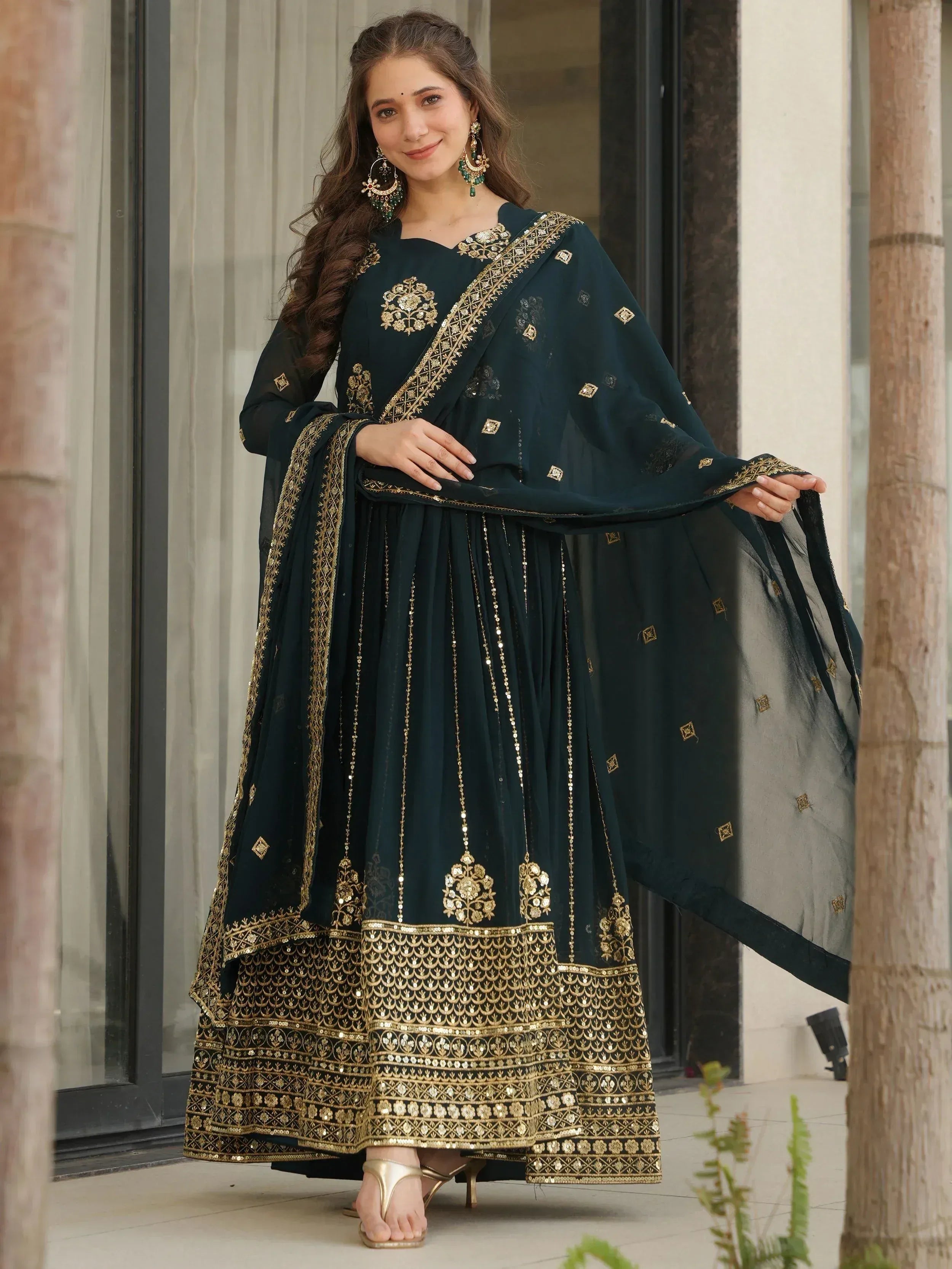 Elegant dark green Indian anarkali suit with gold embroidery and sequin work, perfect for festive occasions.