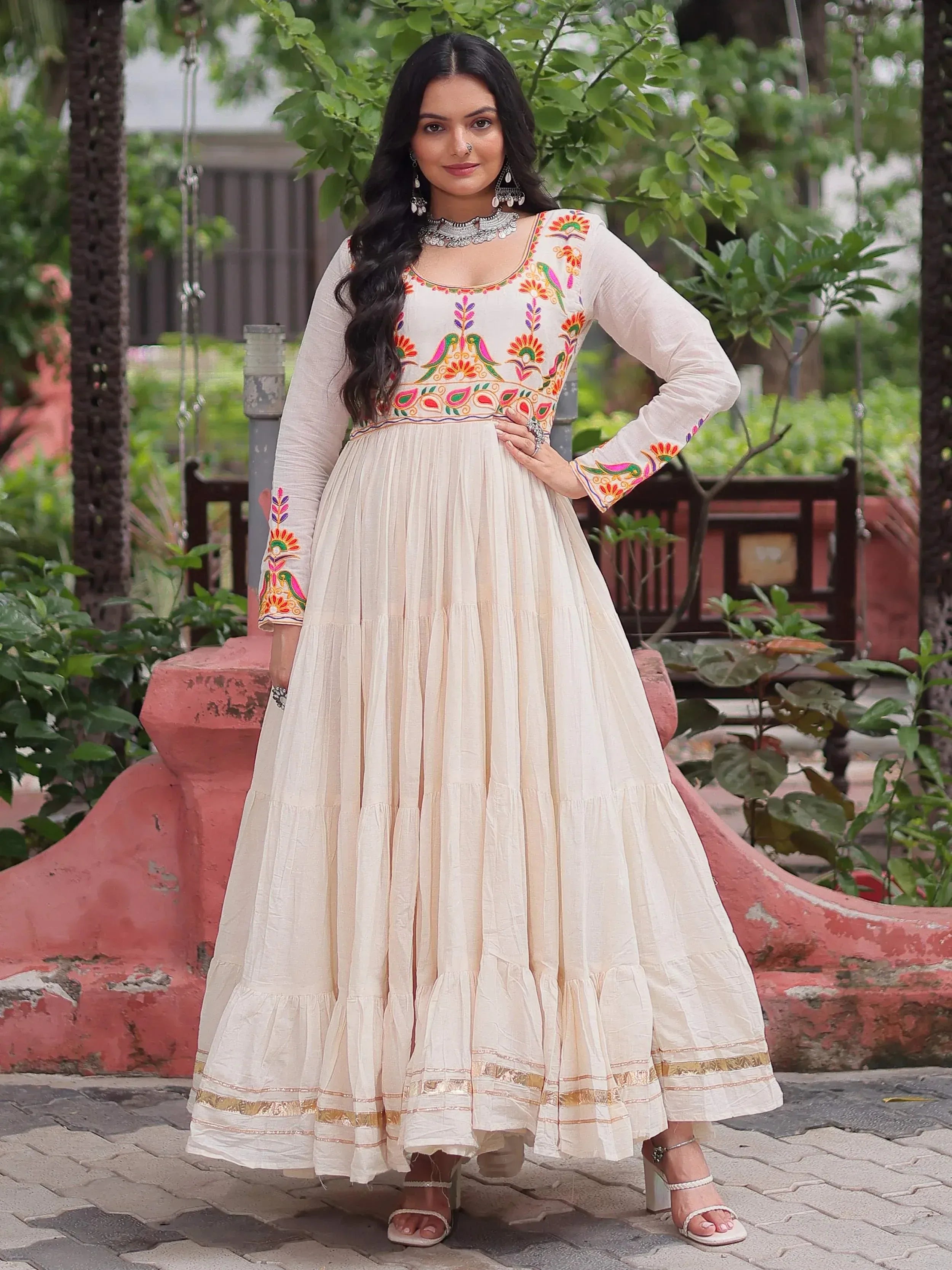 Cream embroidered anarkali gown with colorful bird motifs, perfect for Indian ethnic wear occasions.