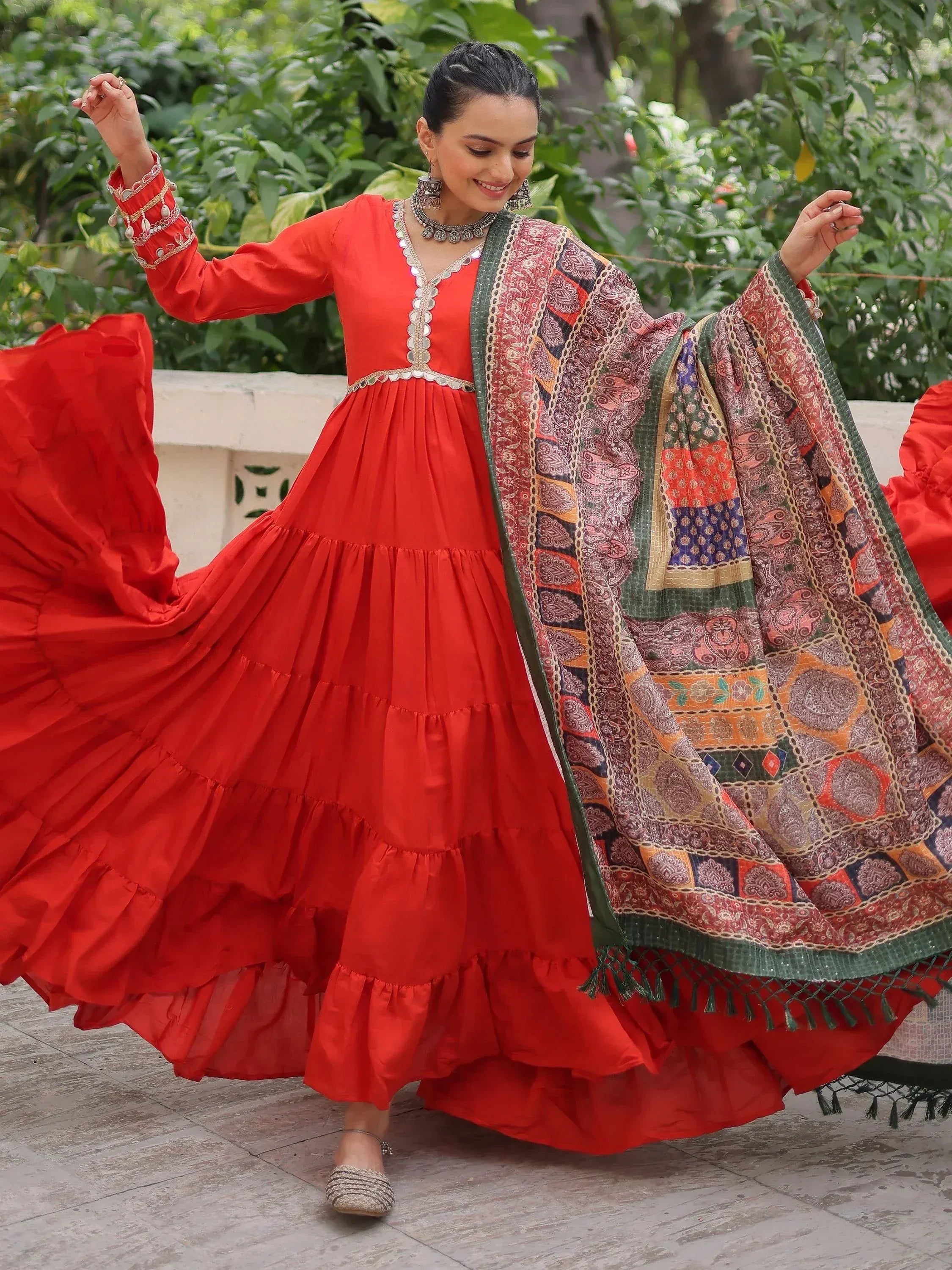 Red tiered ethnic gown with patterned dupatta, perfect for festive occasions