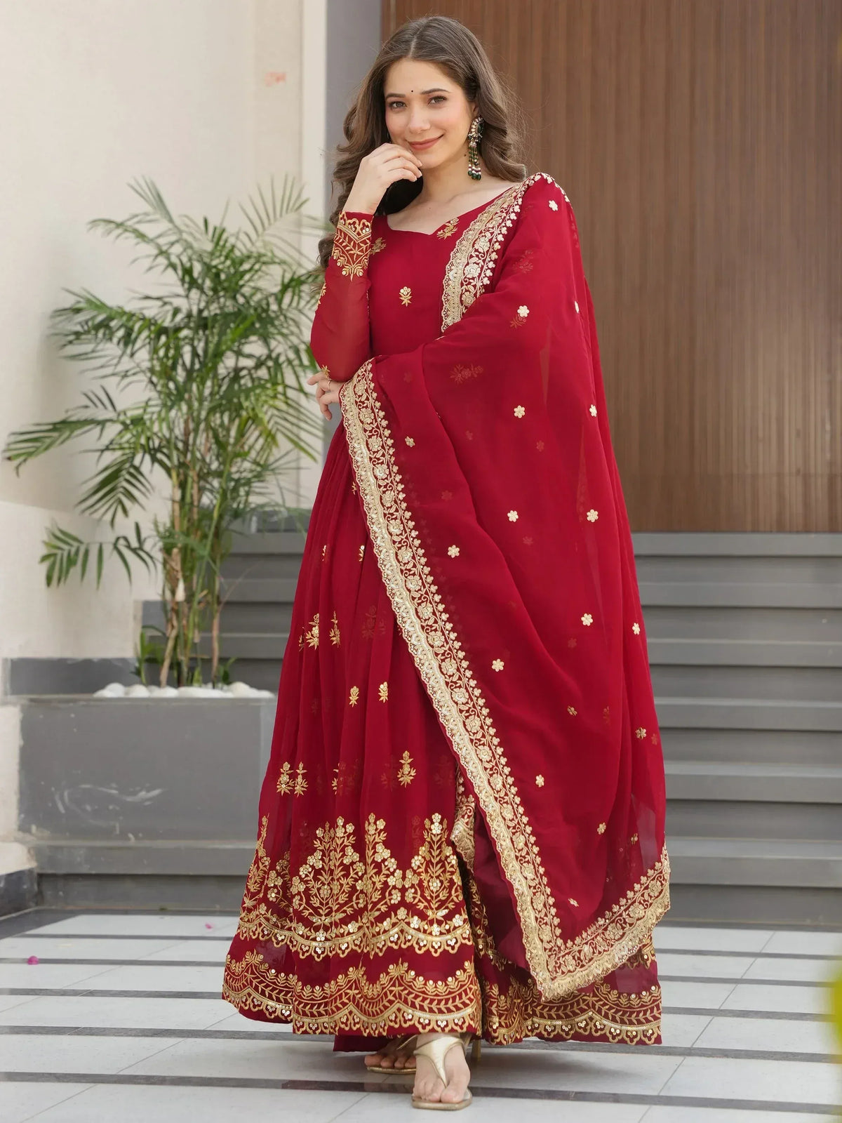 Red ethnic anarkali suit with gold embroidery, perfect for Indian weddings and festive occasions.