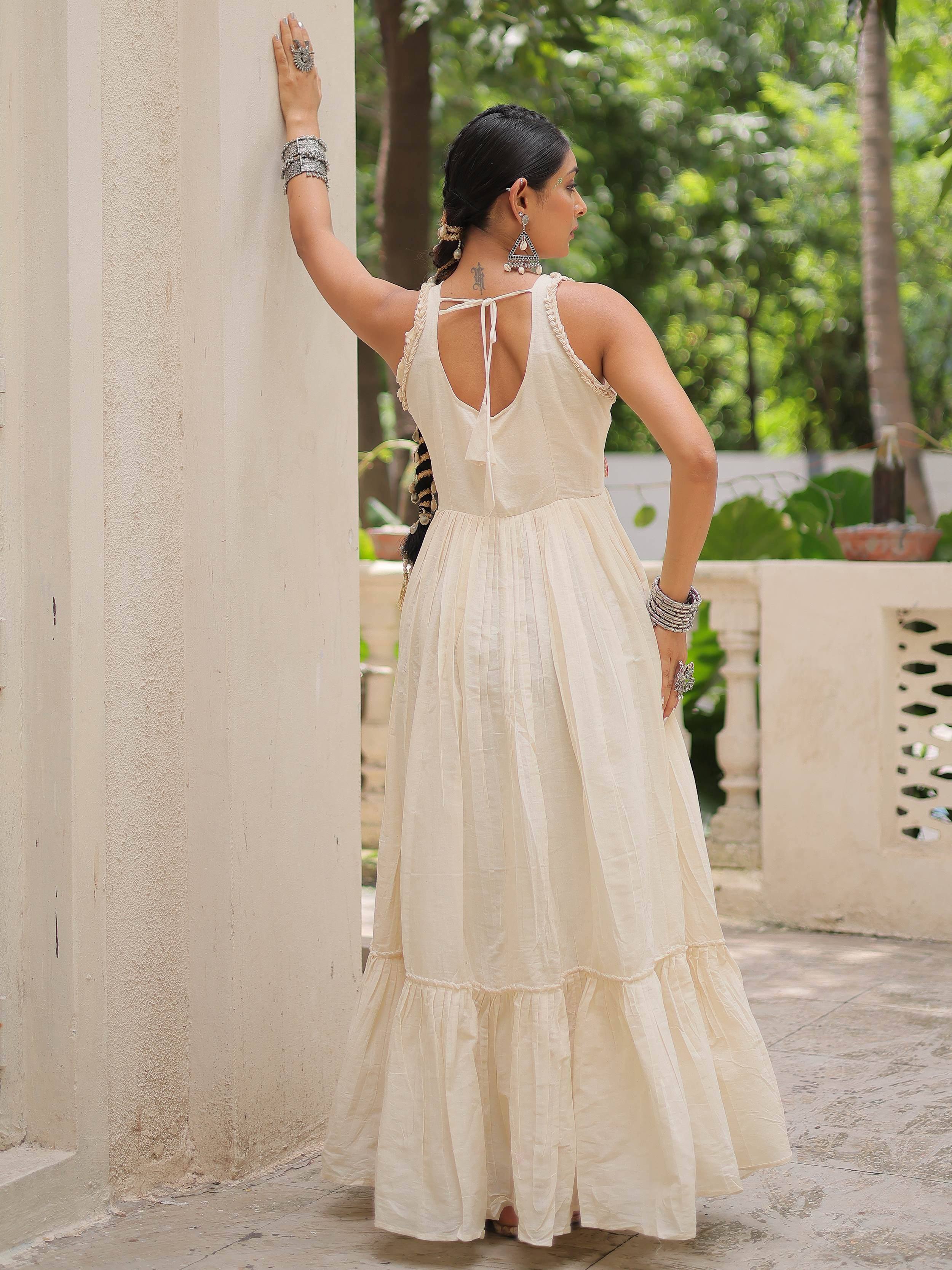 Cream ethnic gown with back tie, ruffled hem, and silver jewelry for Indian wear