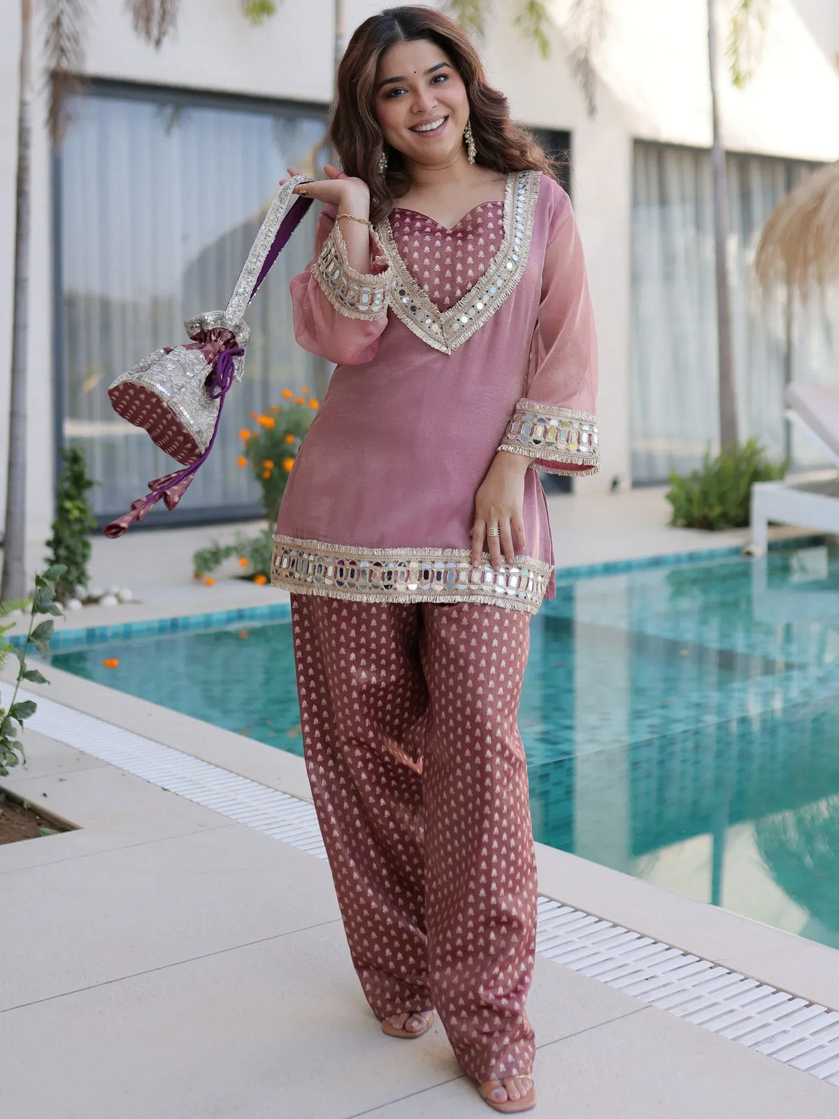 Pink mirror-work salwar kameez with matching potli bag, perfect for Indian ethnic occasions