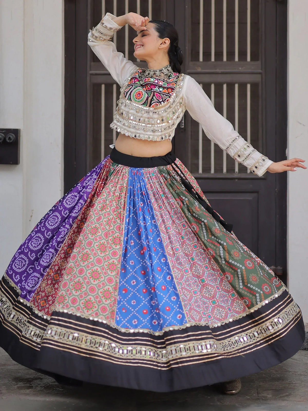 Woman in colorful Indian ethnic wear, embroidered choli and patchwork lehenga skirt, dancing joyfully