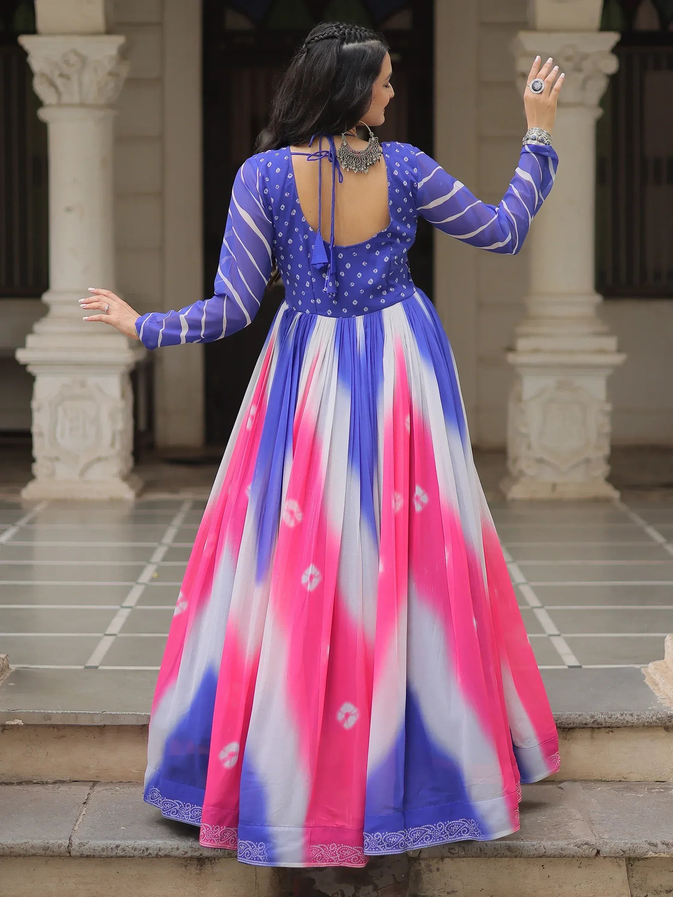 Woman in vibrant blue and pink tie-dye ethnic gown with back tie detail, perfect for Indian occasions