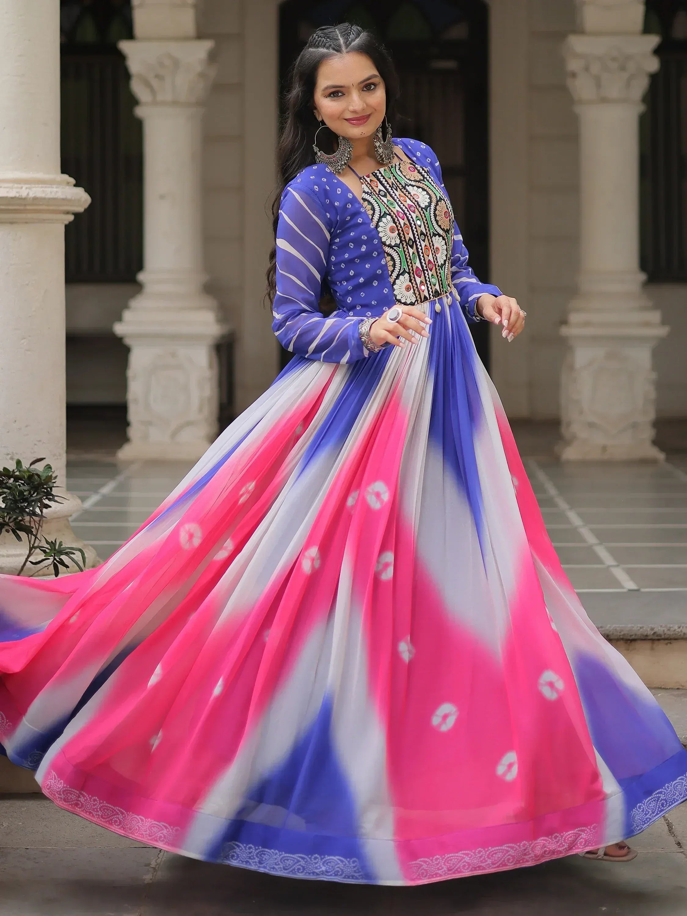 Woman in vibrant blue and pink ethnic gown with floral embroidery, perfect for Indian occasions
