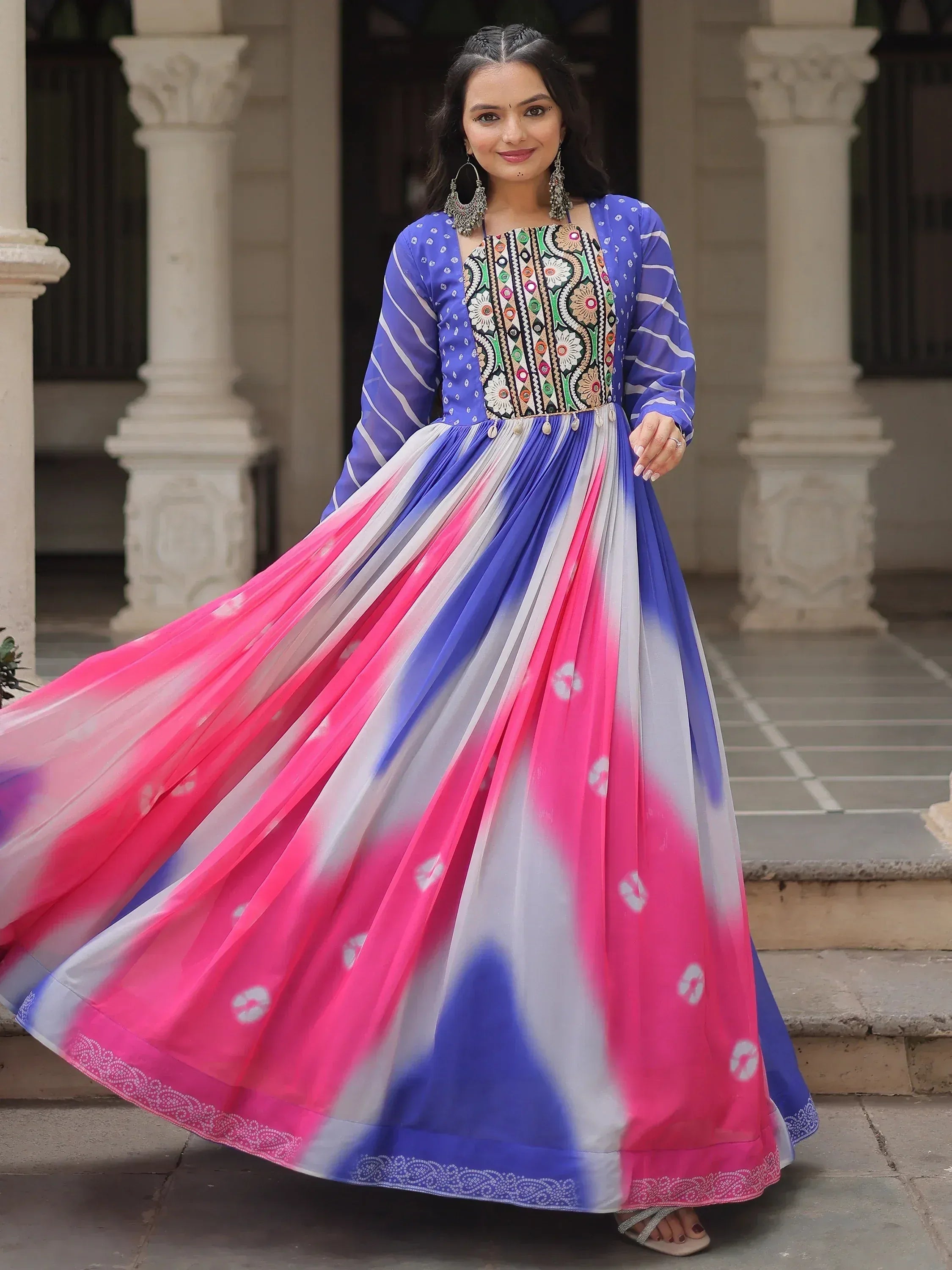 Woman in vibrant blue and pink tie-dye ethnic gown with embroidered bodice, perfect for Indian occasions.