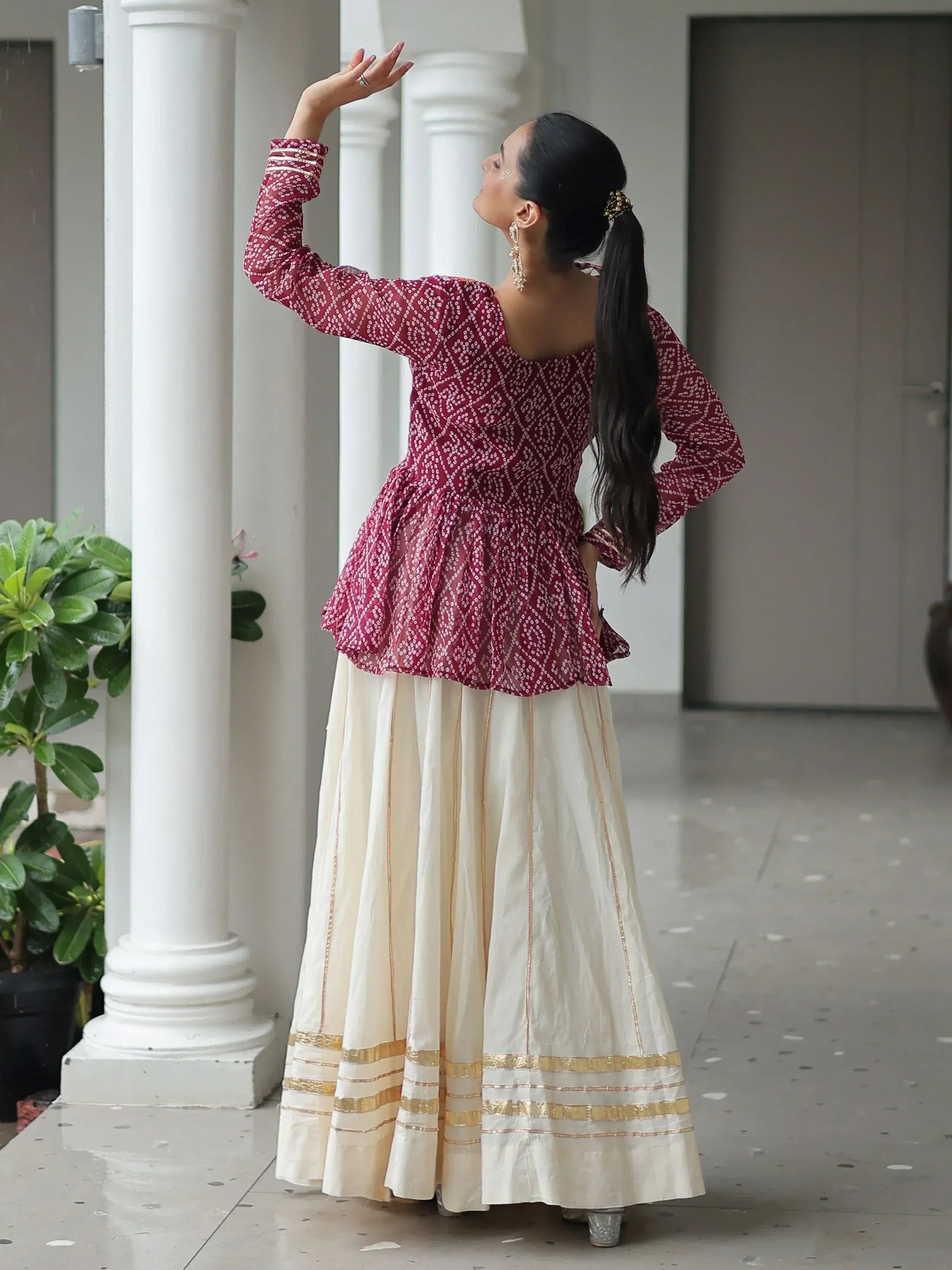 Woman in maroon printed peplum top and cream lehenga skirt, Indian ethnic wear