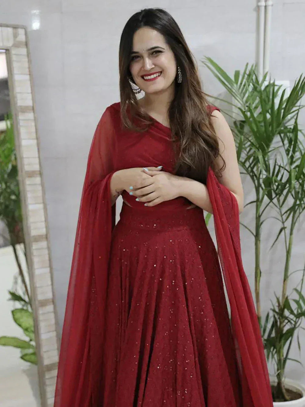 Elegant red ethnic gown with sequins and sheer cape, perfect for festive occasions