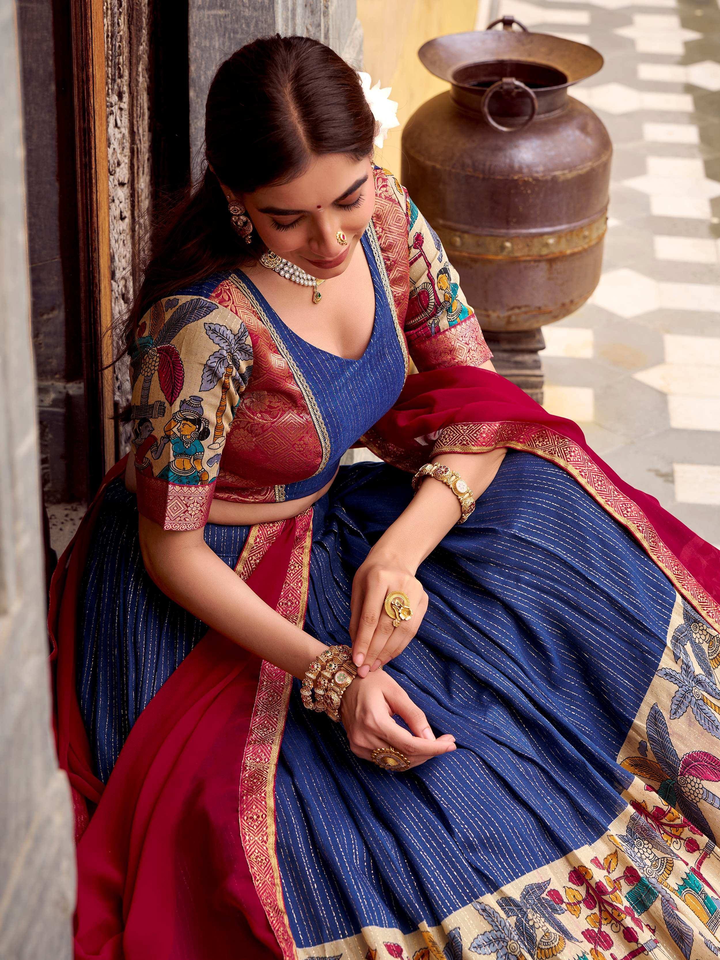 Woman in blue and red printed lehenga choli with gold jewelry, traditional Indian ethnic wear