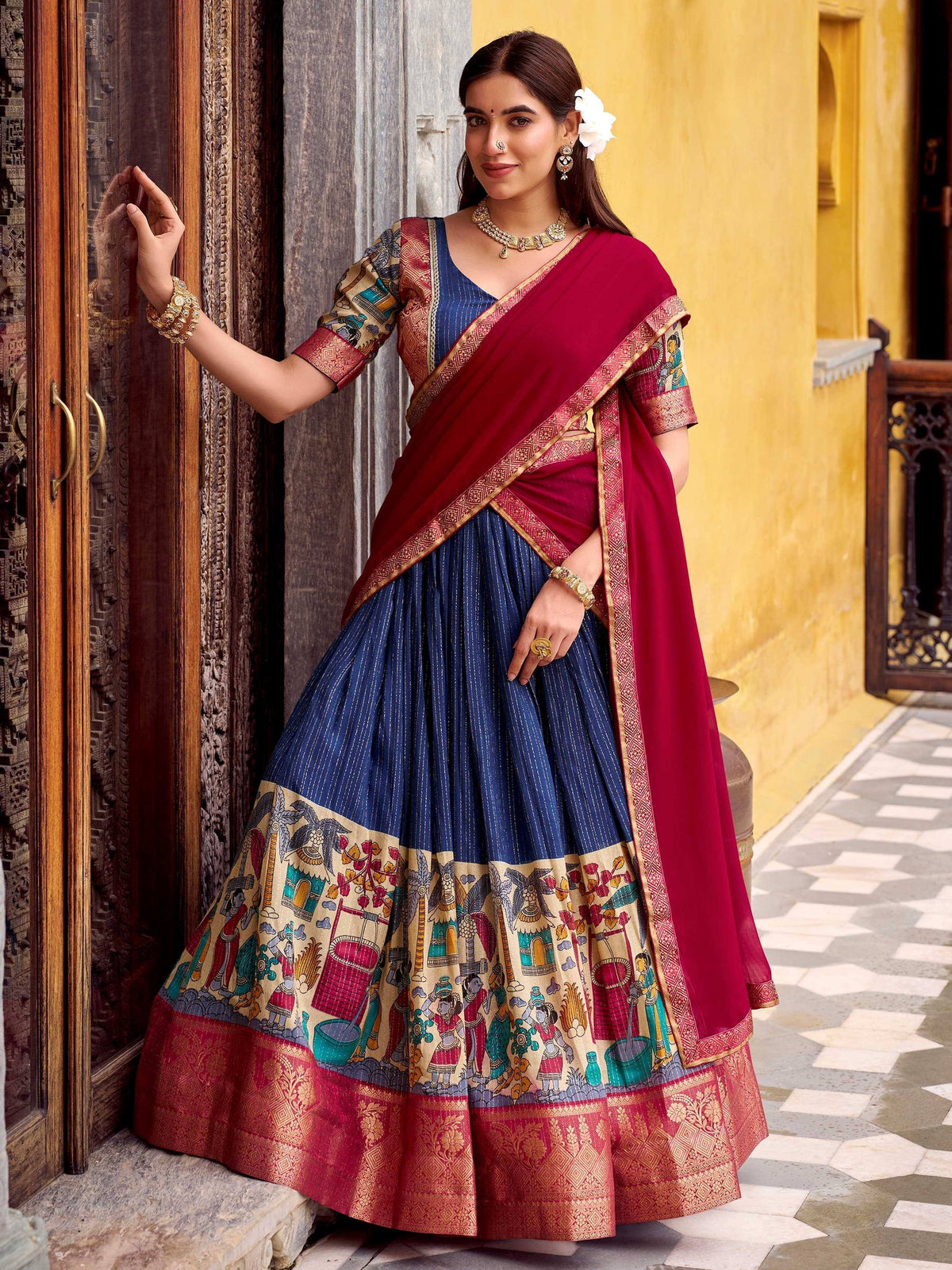 Woman in blue and maroon printed lehenga choli with traditional Indian artwork, ethnic wear