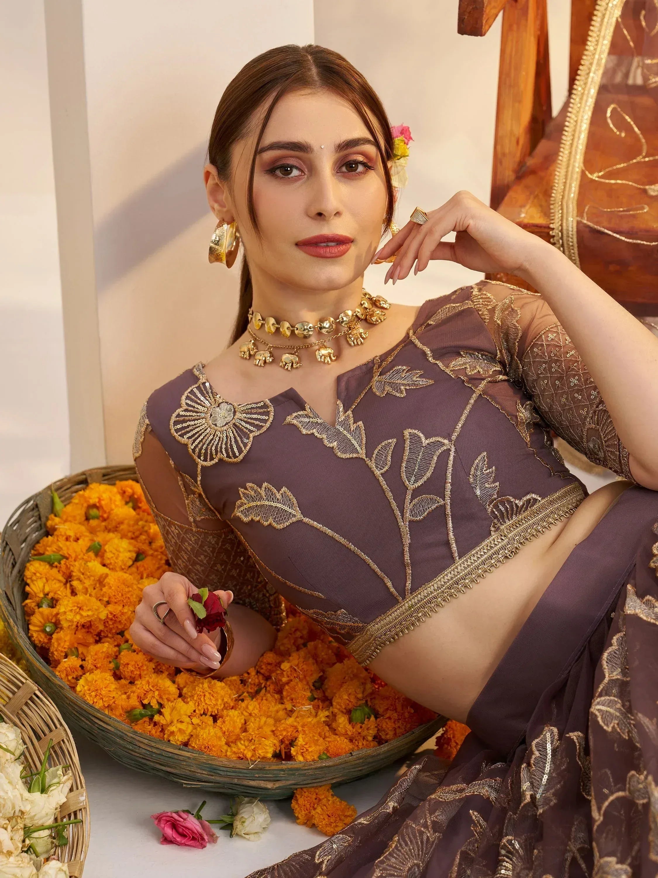 Elegant purple saree with gold floral embroidery, paired with statement gold jewelry, perfect for Indian ethnic occasions.