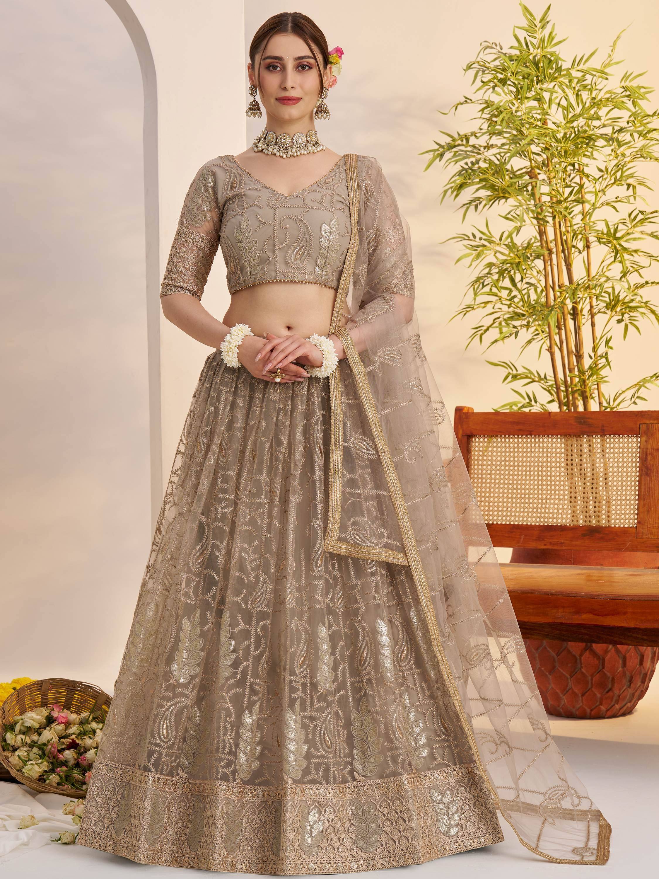 Elegant beige embroidered lehenga choli with gold detailing, perfect for Indian weddings and festive occasions.