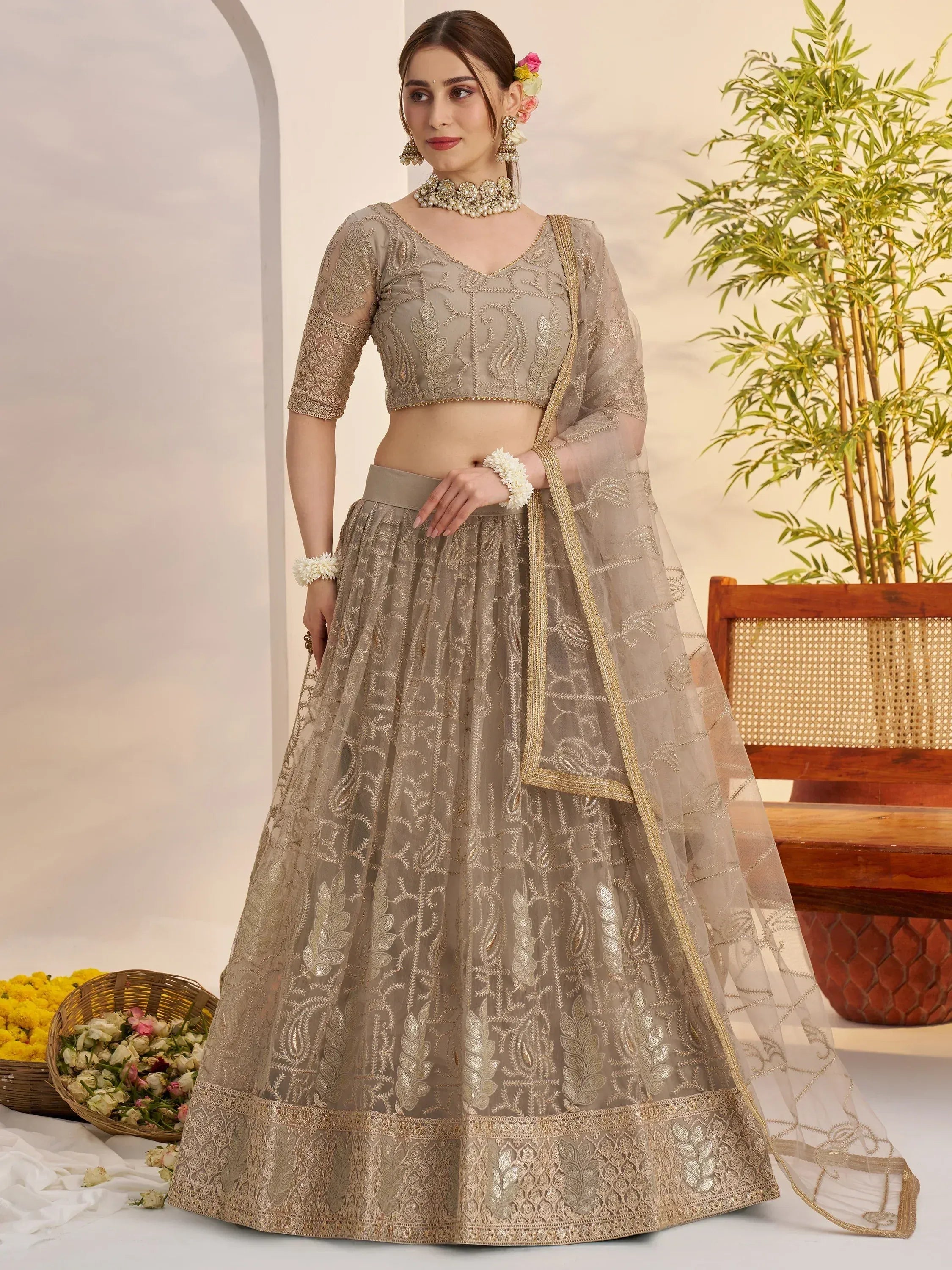 Elegant beige embroidered lehenga choli with gold detailing, perfect for Indian weddings and festive occasions.