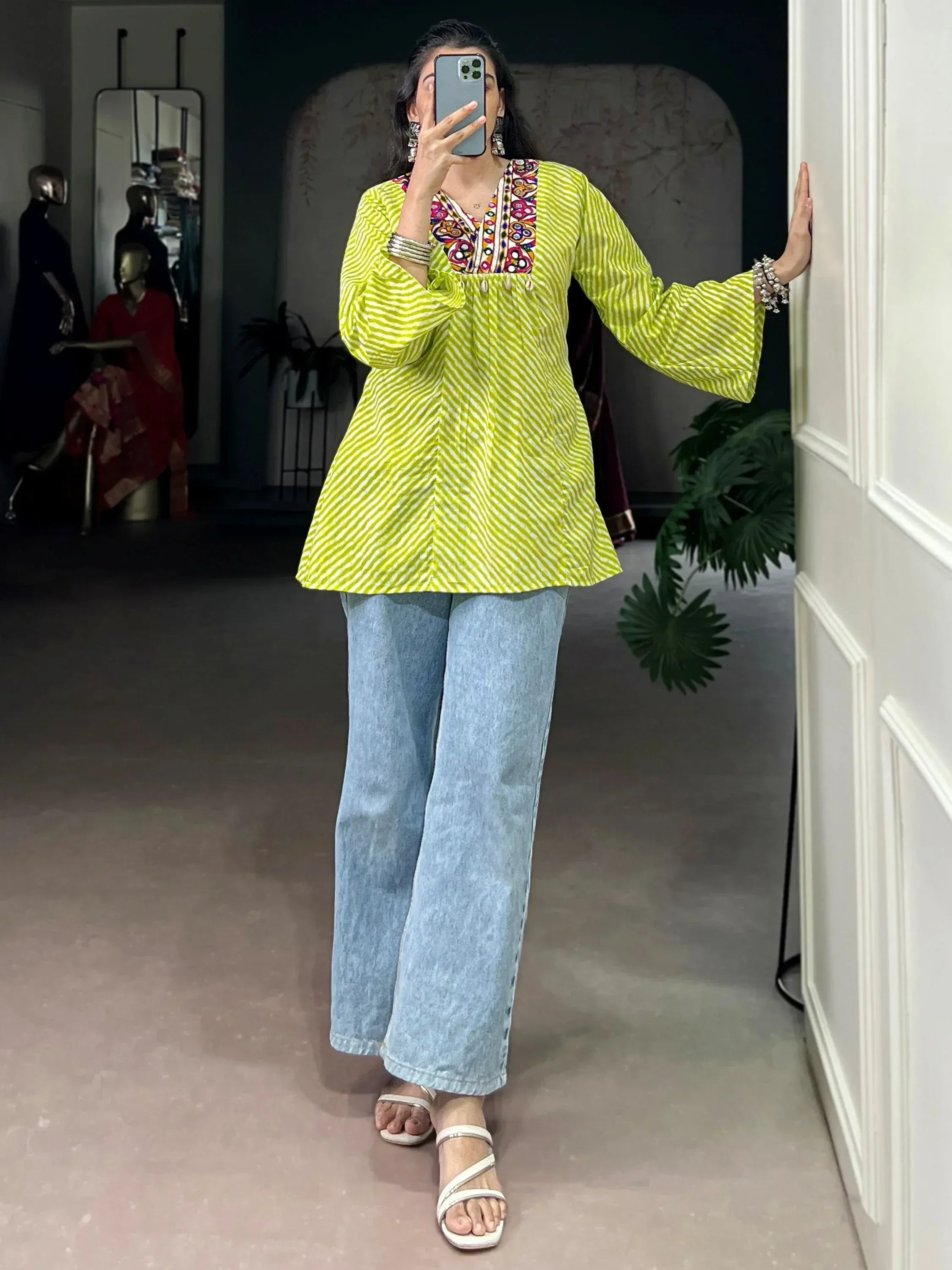 Vibrant green striped ethnic kurta with colorful embroidery, paired with wide-leg denim pants for a stylish fusion look.