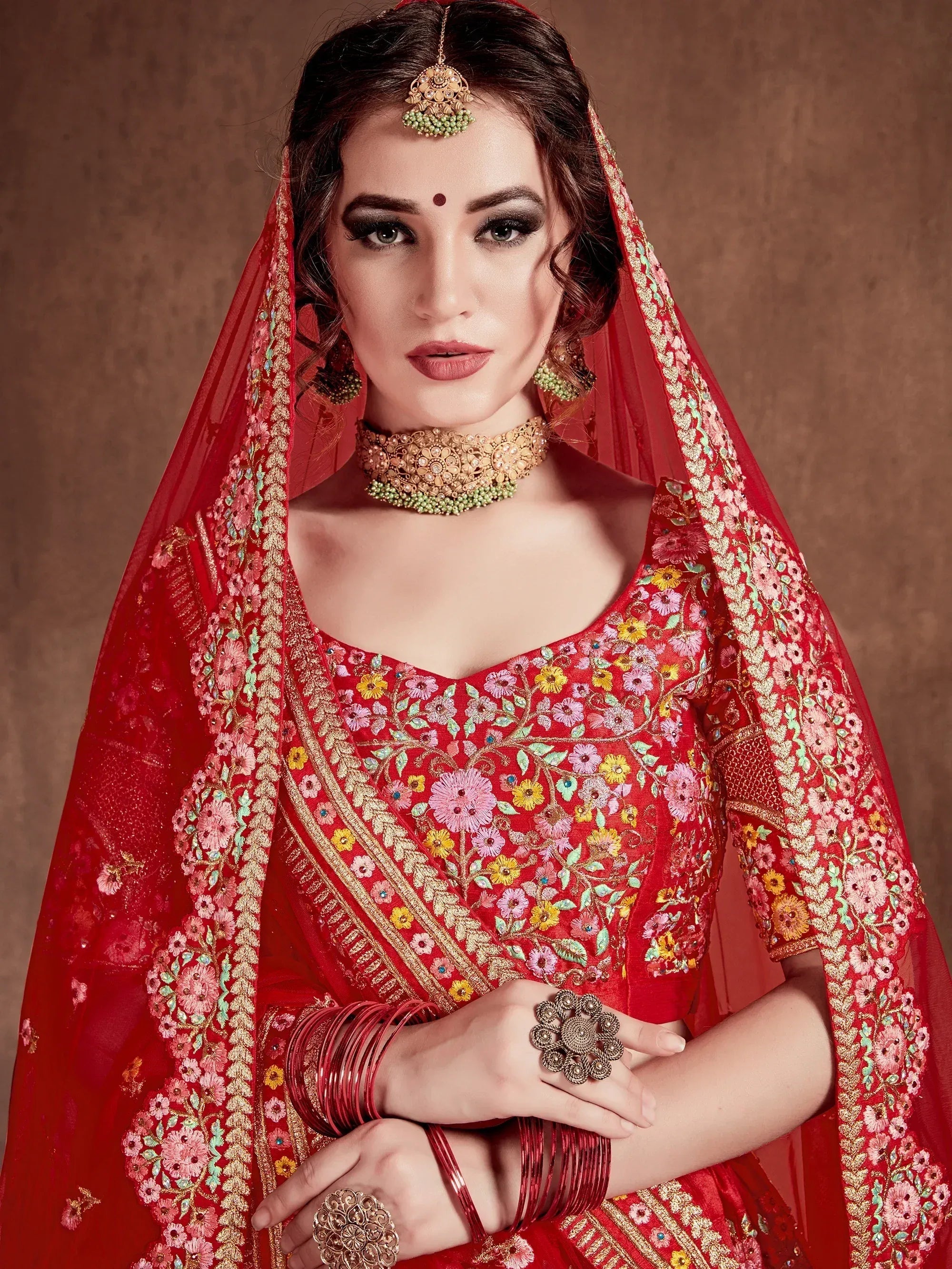 Red floral embroidered lehenga choli with matching dupatta and traditional jewelry for Indian weddings