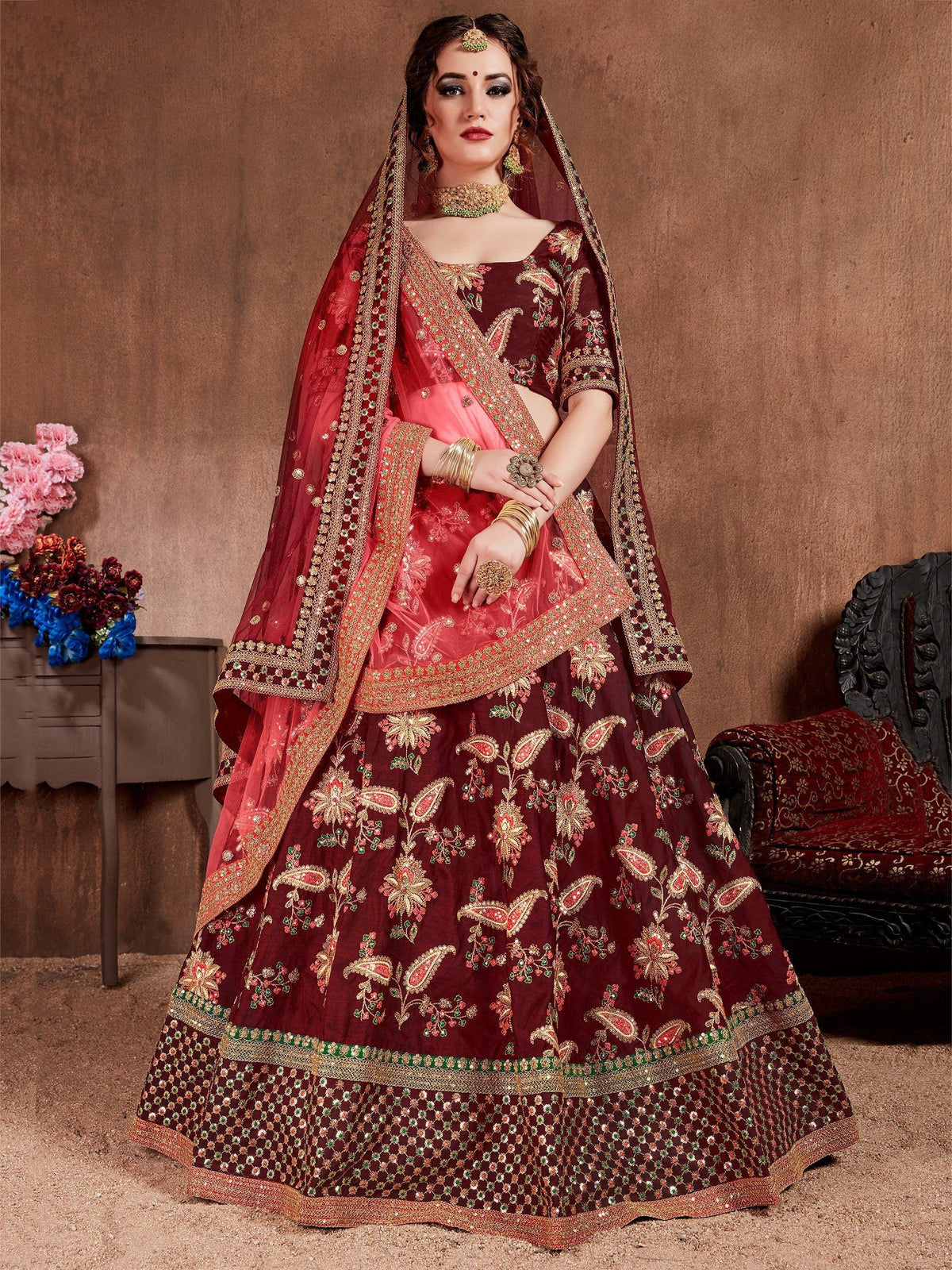 Maroon embroidered lehenga choli with gold detailing, perfect for Indian weddings and festive occasions.