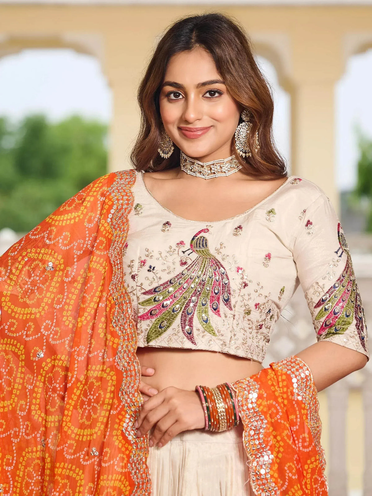 Woman in cream peacock-embroidered crop top with orange dupatta, Indian ethnic wear
