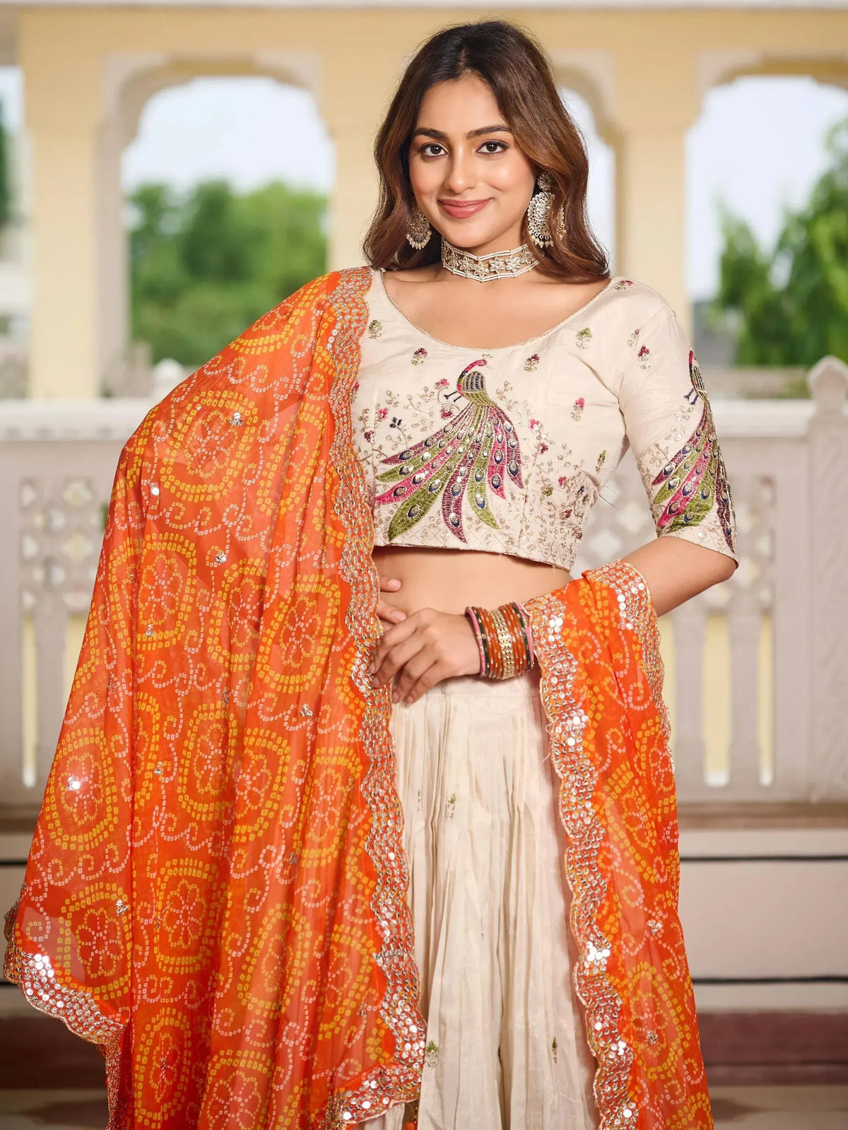 Woman in cream peacock-embroidered crop top with orange patterned dupatta, Indian ethnic wear