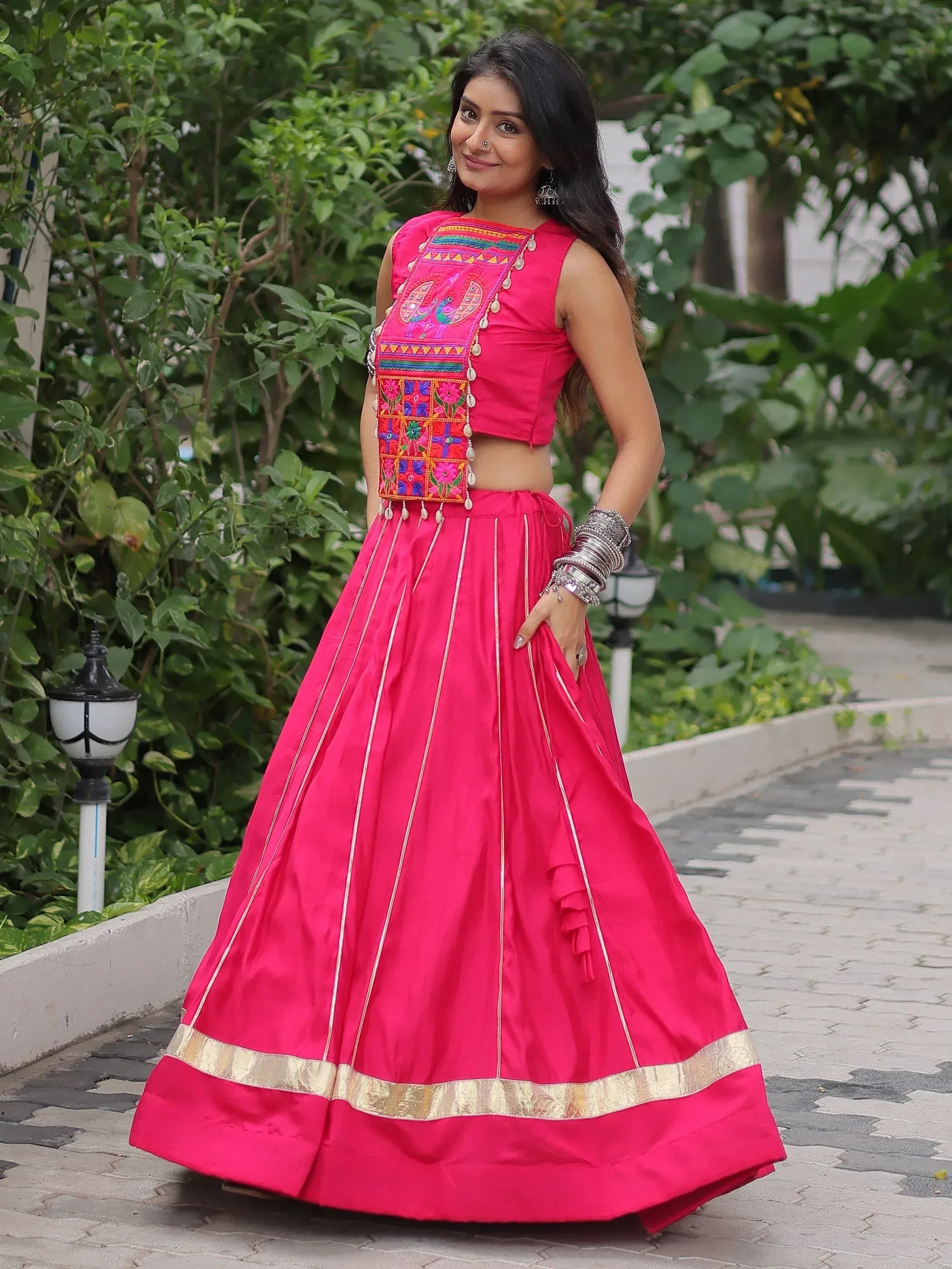 Vibrant pink embroidered lehenga choli with gold border, perfect for Indian ethnic occasions