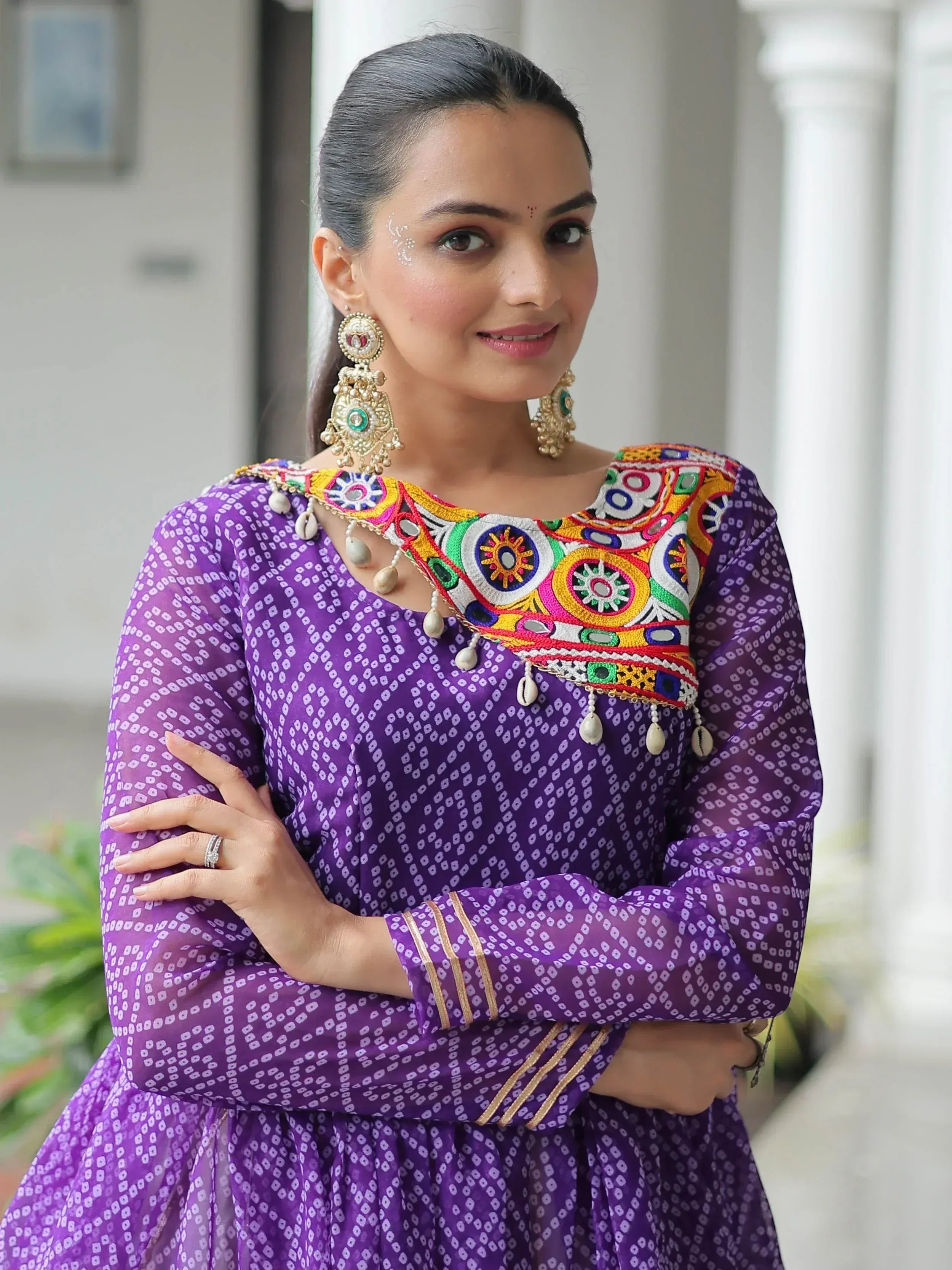 Purple ethnic gown with colorful mirror embroidery and traditional jewelry