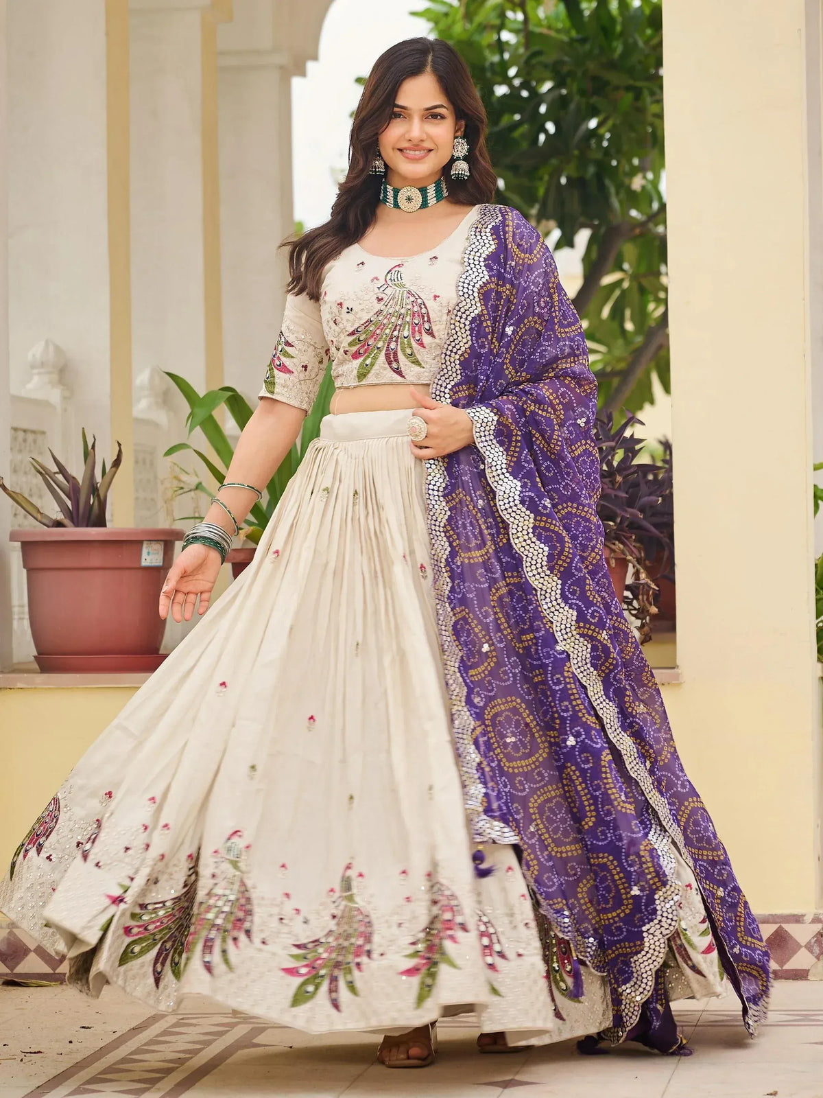 Woman in cream peacock-embroidered lehenga choli with purple sequin dupatta, Indian ethnic wear