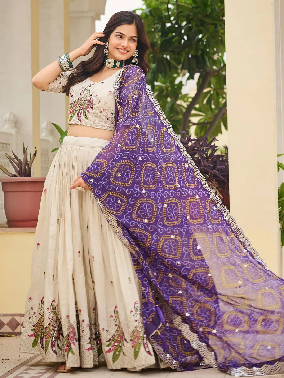 Elegant cream lehenga choli with peacock embroidery and purple sequin dupatta, perfect for Indian ethnic occasions.