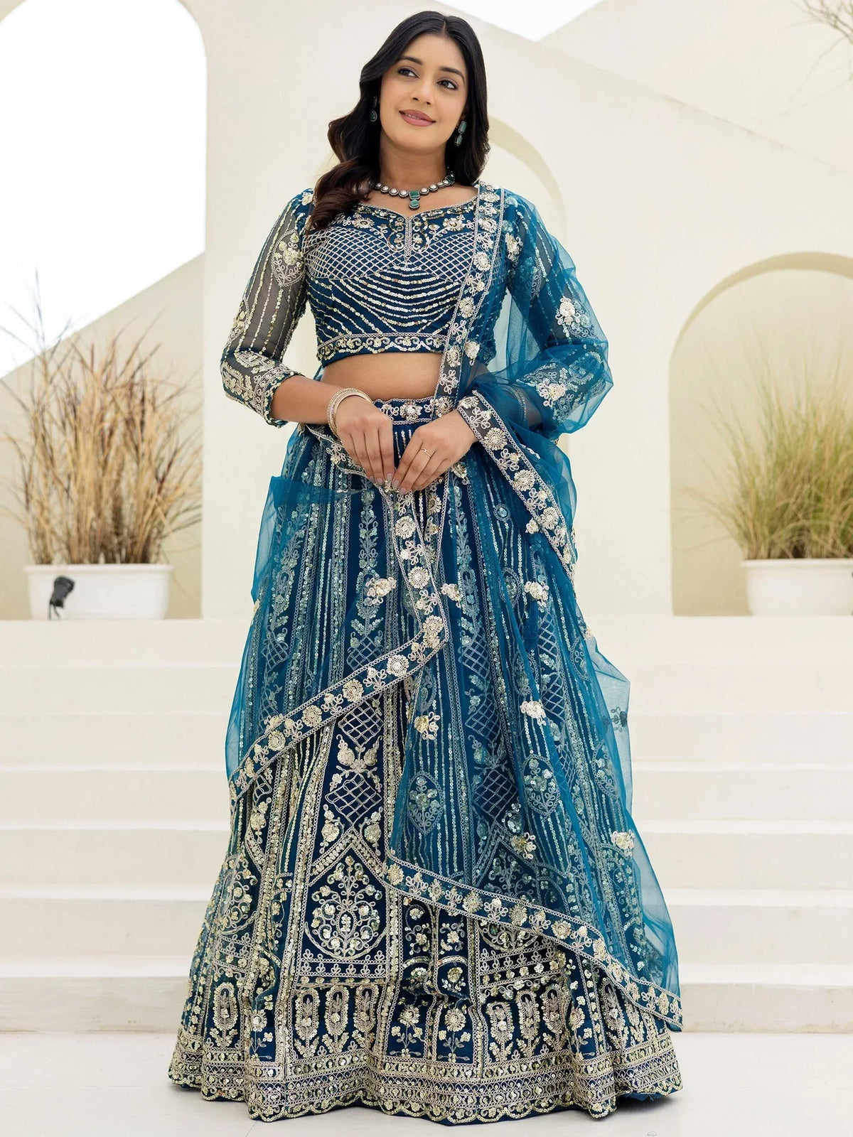 Blue embroidered lehenga choli with sheer sleeves, perfect for Indian weddings and festive occasions.