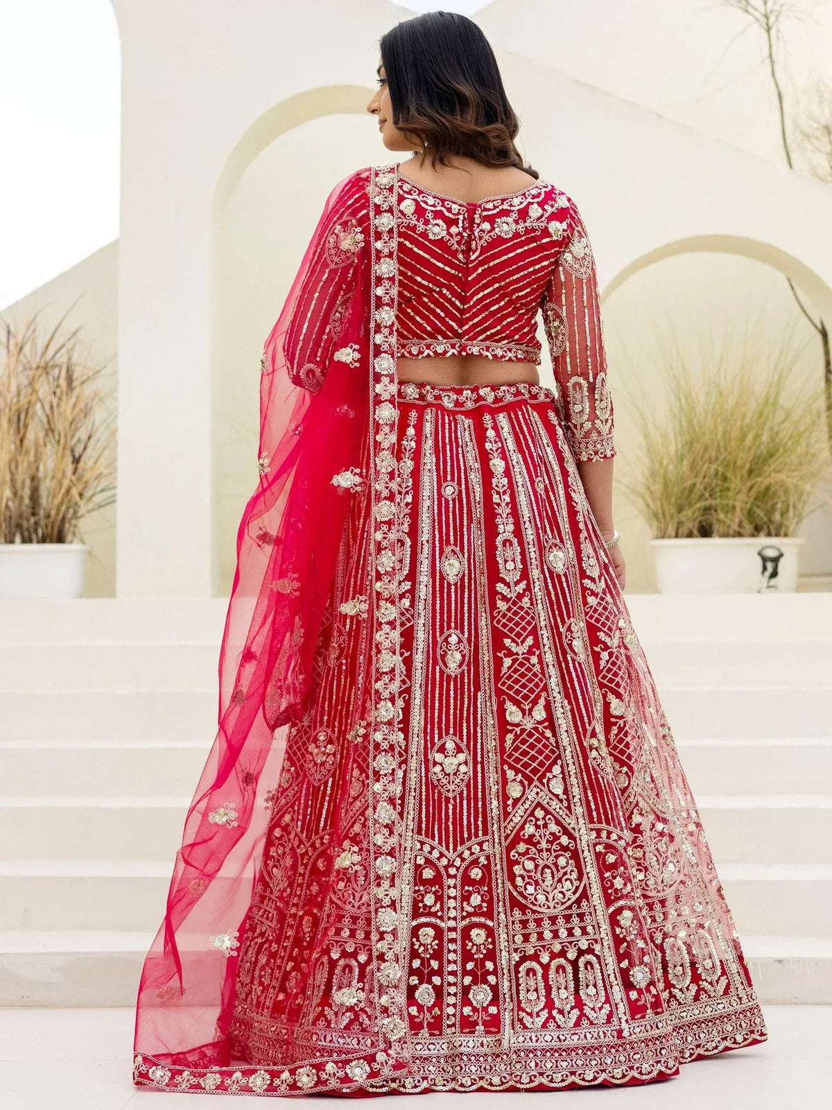 Red embroidered lehenga choli with gold detailing, perfect for Indian weddings and festive occasions.