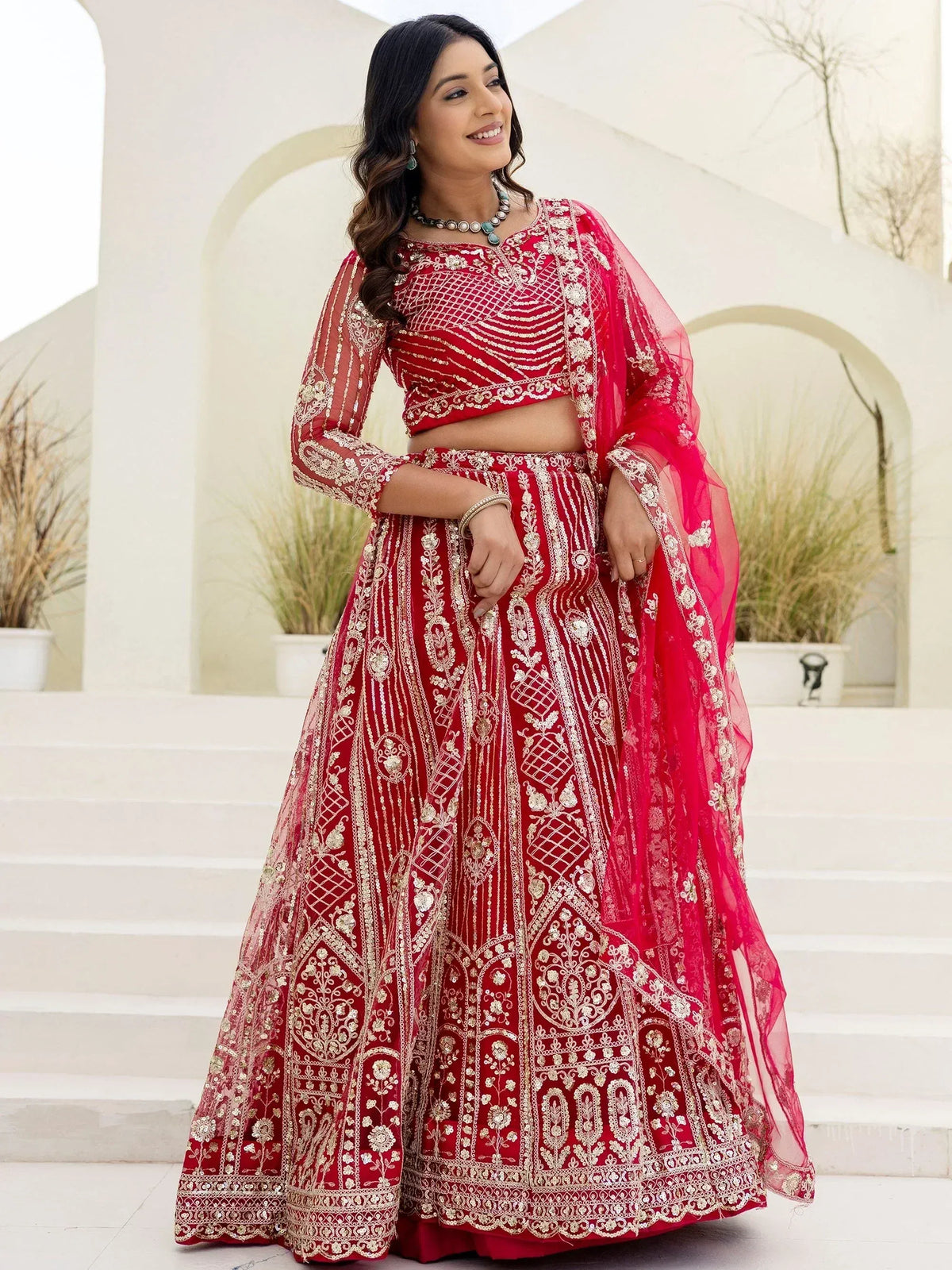 Red embroidered lehenga choli with gold detailing, perfect for Indian weddings and festive occasions.
