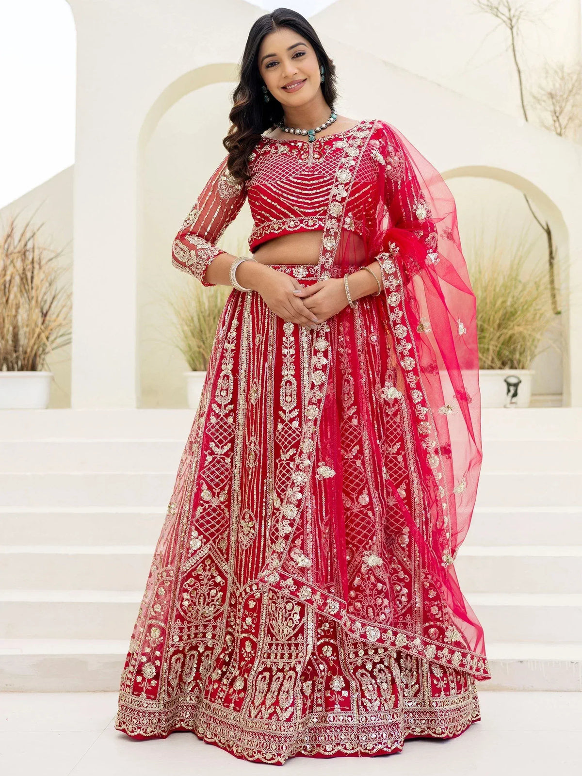Red embroidered lehenga choli with gold detailing, perfect for Indian weddings and festive occasions.