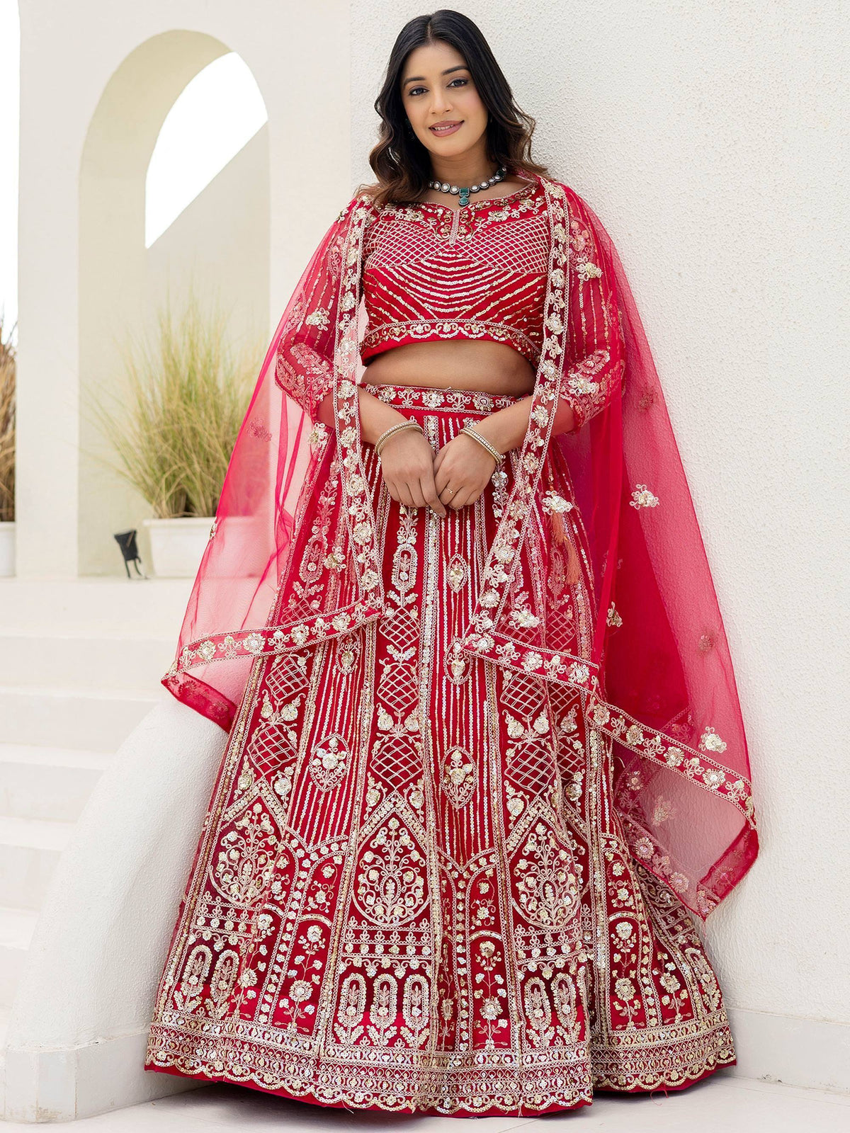 Red embroidered lehenga choli with gold detailing, perfect for Indian weddings and festive occasions.