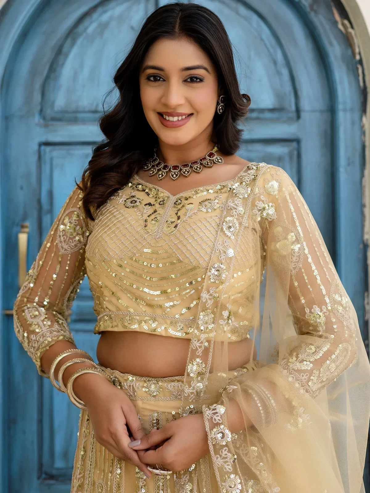 Elegant gold embroidered lehenga choli with sheer sleeves and floral detailing