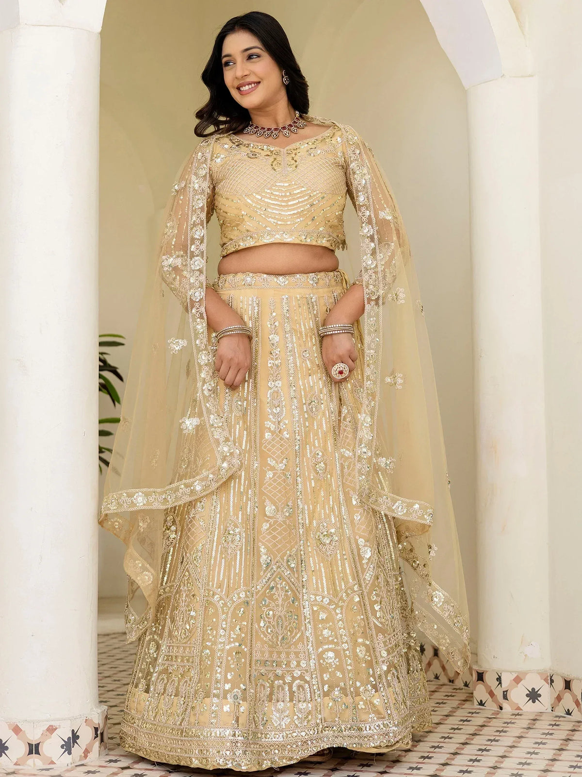 Elegant beige designer lehenga choli with heavy embroidery and sheer dupatta for Indian weddings