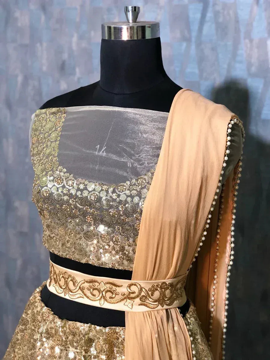 Gold sequin lehenga choli with sheer blouse and pearl-trimmed dupatta, ethnic Indian wear
