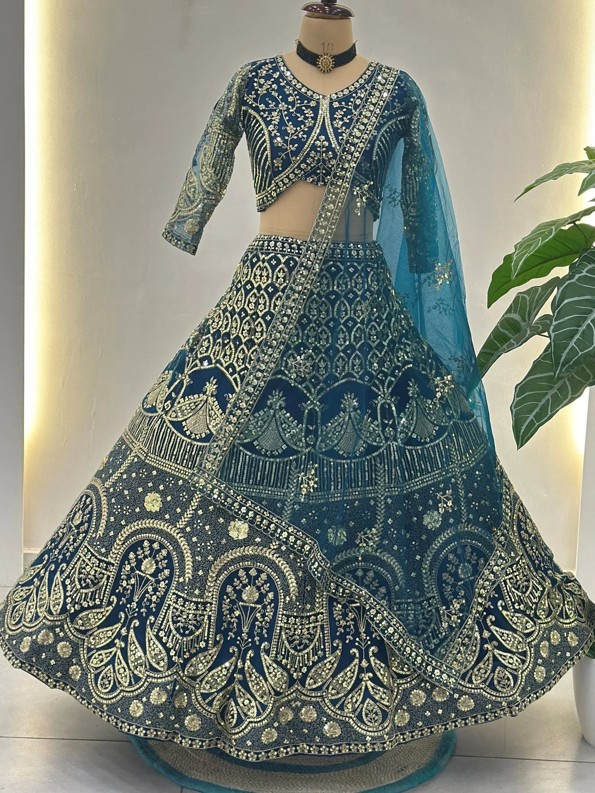 Blue and gold embroidered lehenga choli with peacock motifs, perfect for Indian weddings and festive occasions.
