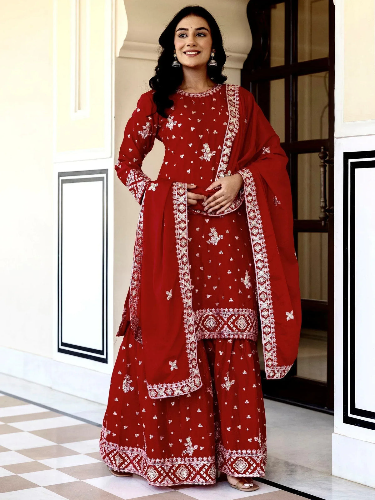 Red embroidered salwar kameez with white floral motifs, perfect for Indian ethnic wear and festive occasions.